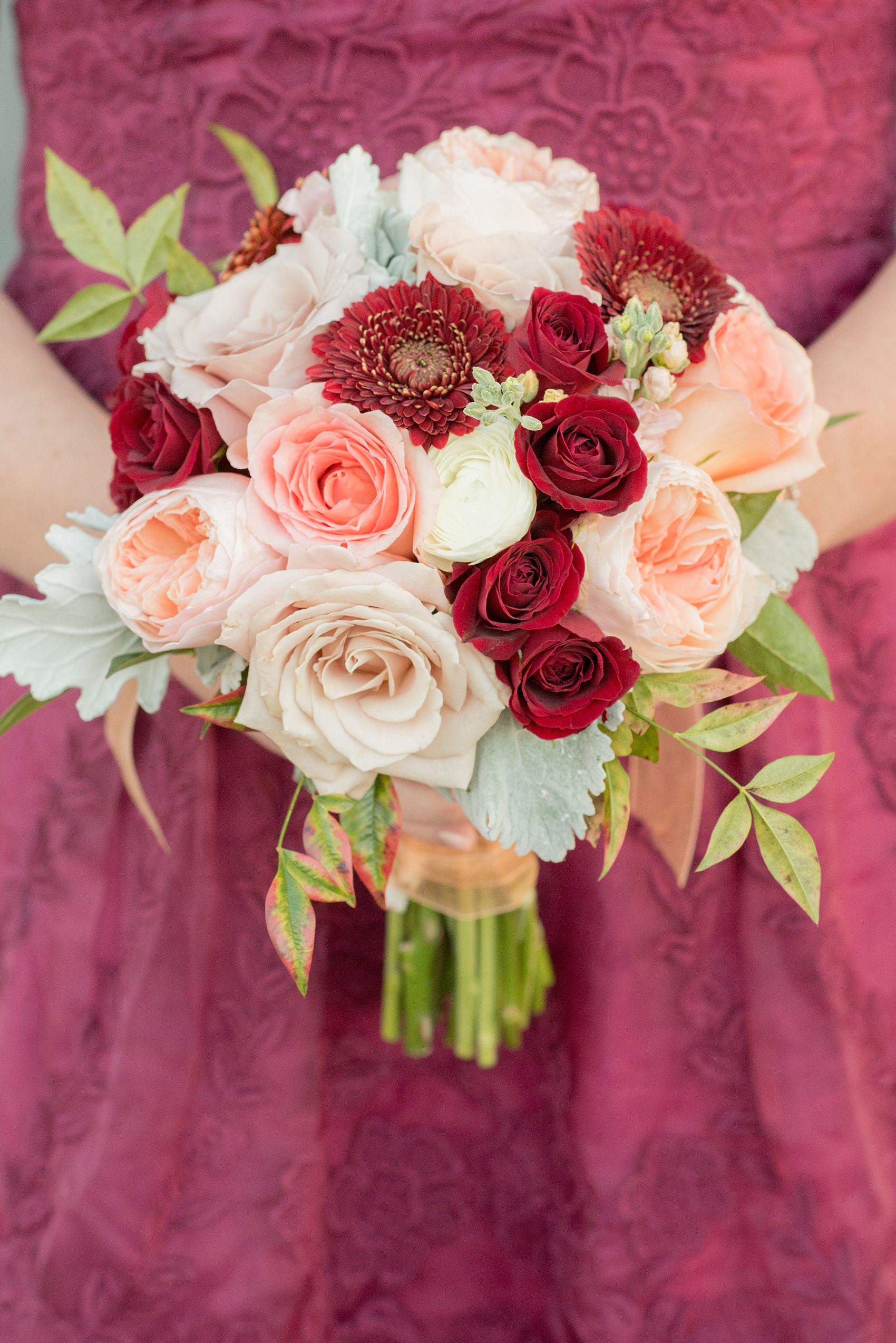 Mikkel Paige Photography photo of a wedding at The Rickhouse, Durham. Picture of the bridesmaid's red, peach and white antique fall bouquet.