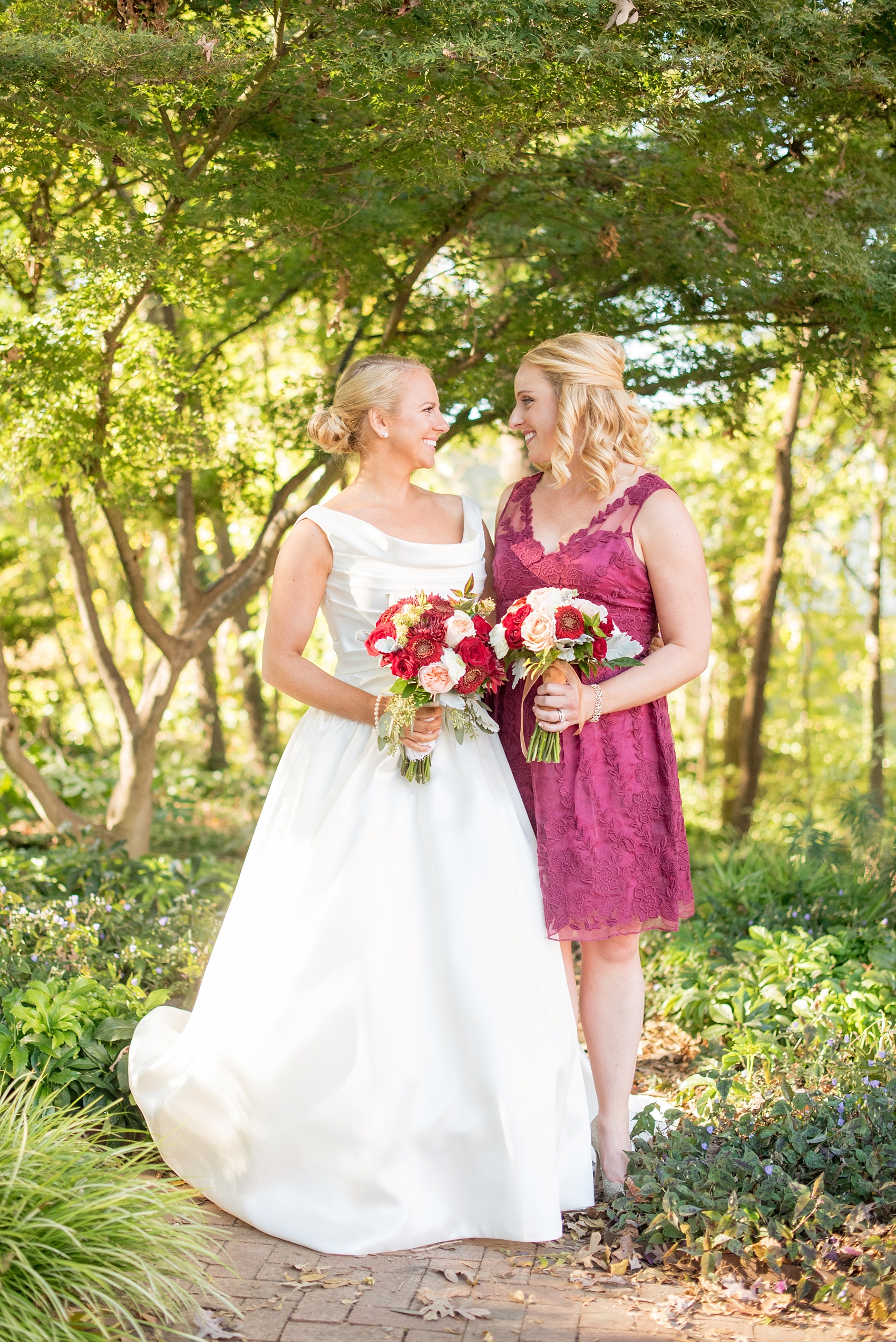 Mikkel Paige Photography photo of a wedding at The Rickhouse, Durham. The maid of honor/bridesmaid wore a short lace burgundy dress and carried an antique fall bouquet.