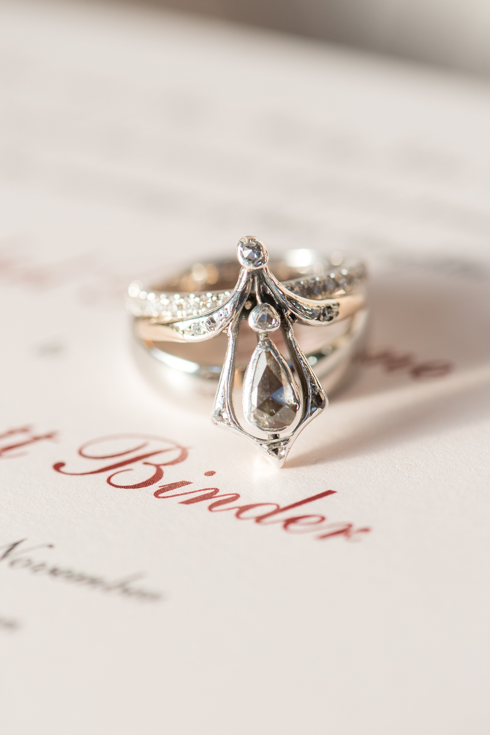 Mikkel Paige Photography photo of a wedding at The Rickhouse, Durham. A detail image of the bride and grooms wedding bands and a unique heirloom engagement ring with teardrop/diamond detail.