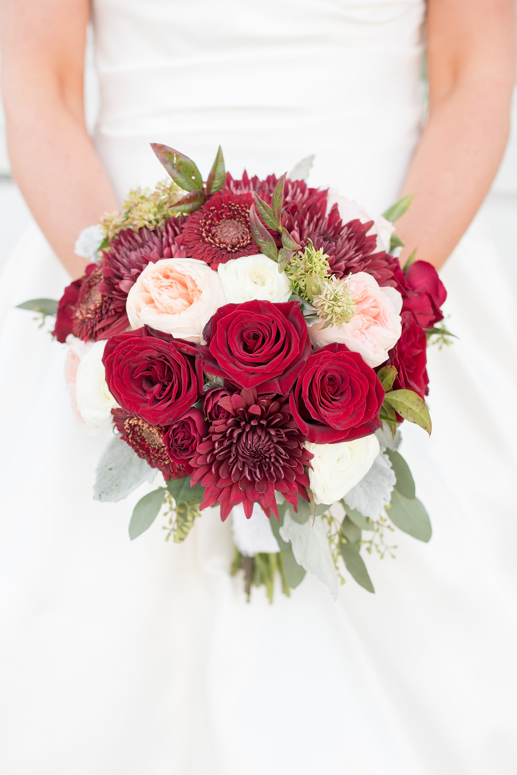 Mikkel Paige Photography photo of a wedding at The Rickhouse, Durham. Picture of the bride's fall inspired bouquet with red, peach and white antique flowers including roses, dahlias and eucalyptus.