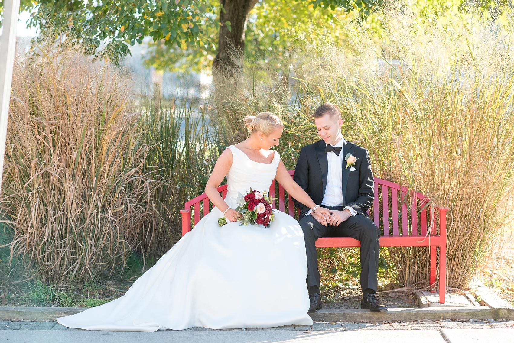Mikkel Paige Photography photo of a wedding at The Rickhouse, North Carolina. Pictures of the bride and groom sitting amongst wild grasses in golden hour sunlight.