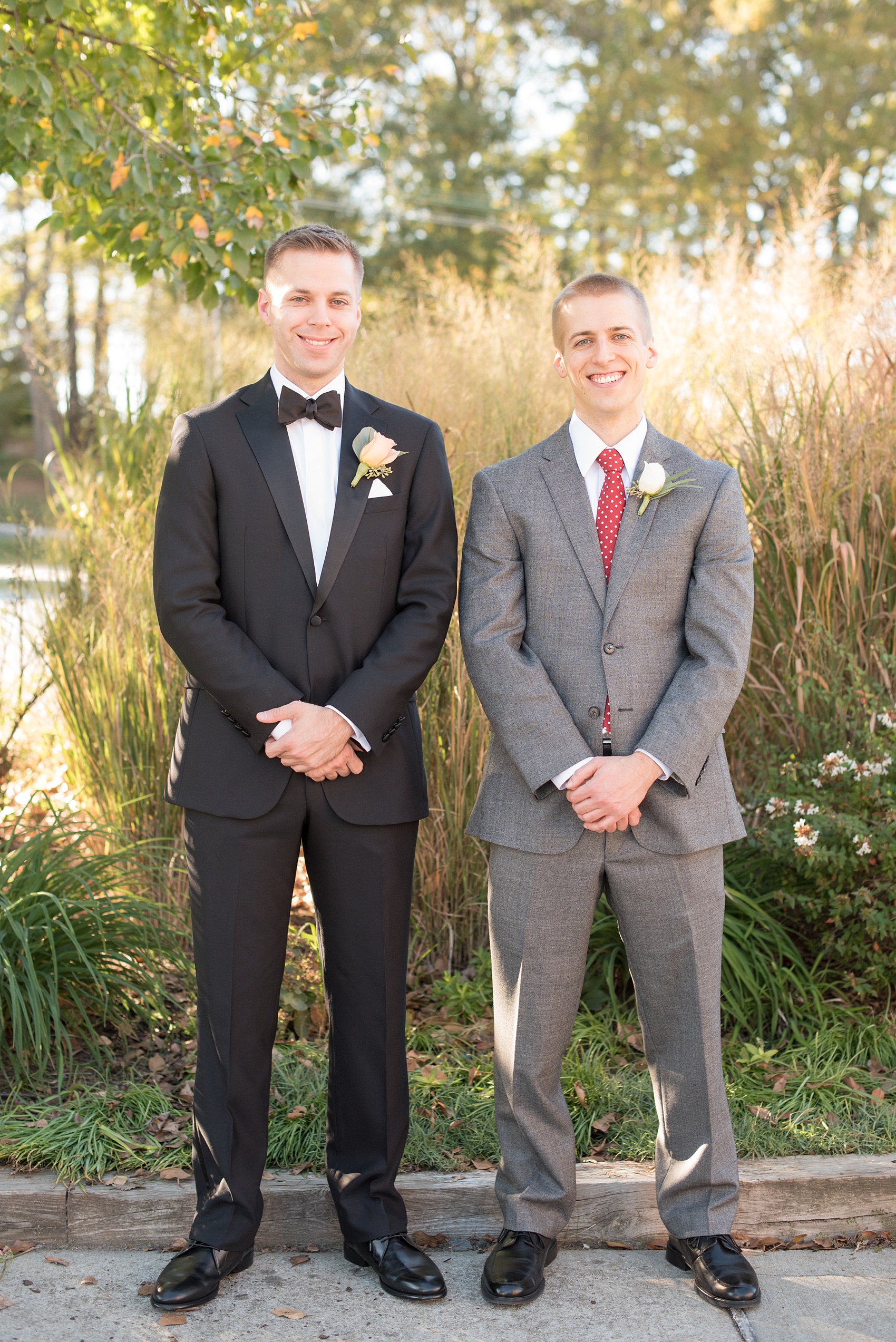 Mikkel Paige Photography photo of a wedding at The Rickhouse, Durham. The best man and groomsman wore a red and white polka dot tie and grey suit with a rose boutonniere and groom a classic tuxedo.