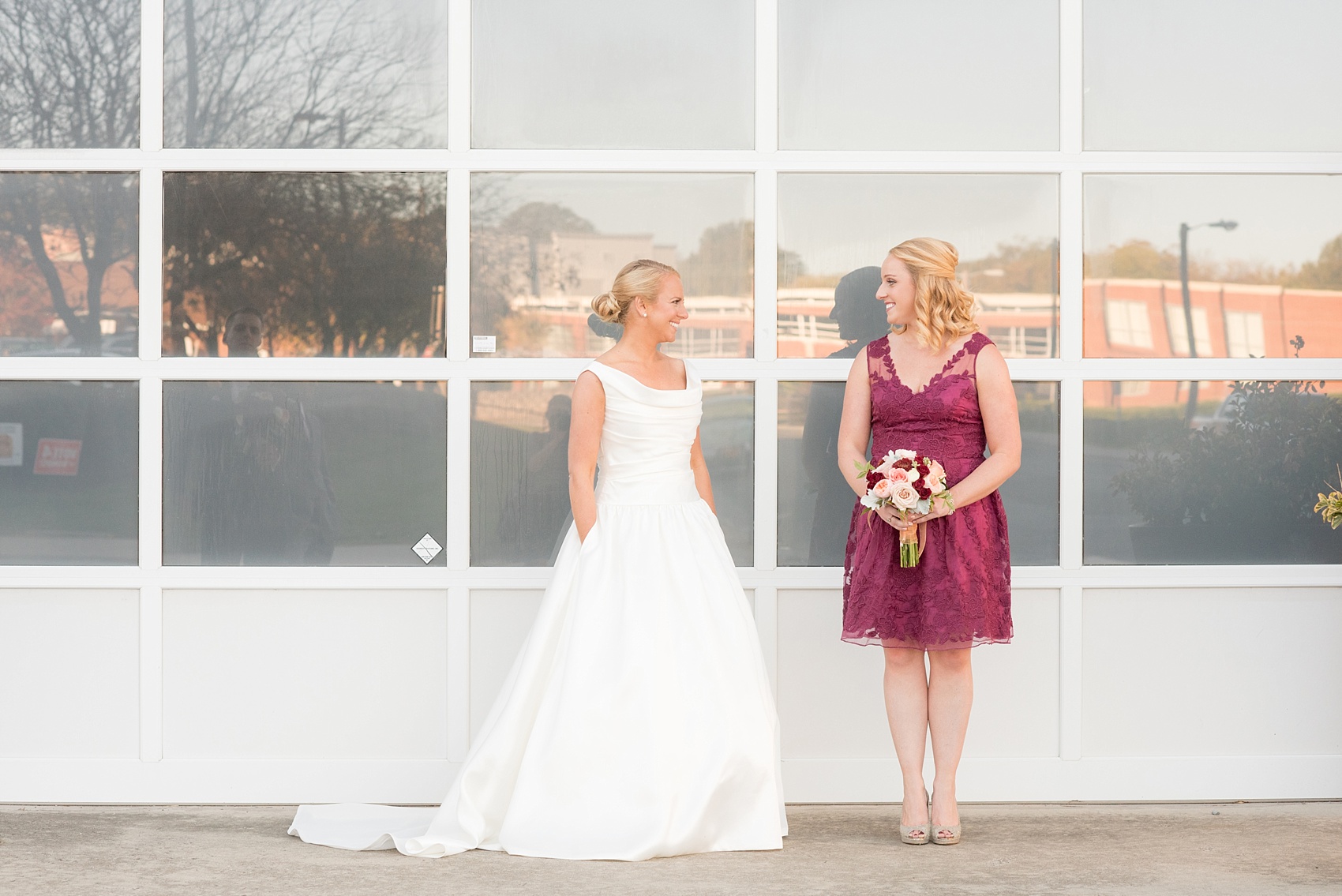 Mikkel Paige Photography photo of a wedding at The Rickhouse, Durham. The maid of honor/bridesmaid wore a short lace burgundy dress and carried an antique fall bouquet.