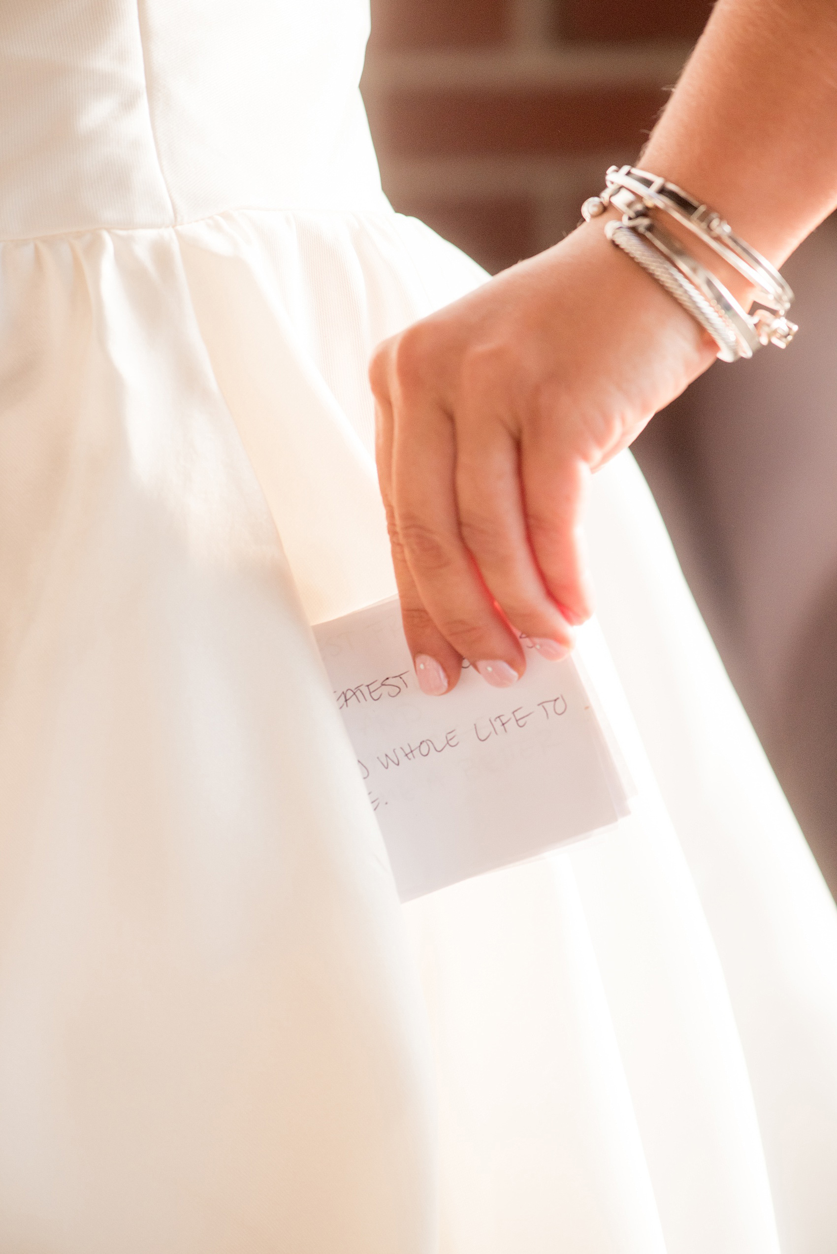 Mikkel Paige Photography photo of a wedding at The Rickhouse, Durham. A picture of the bride's vows being placed in her gown pocket.