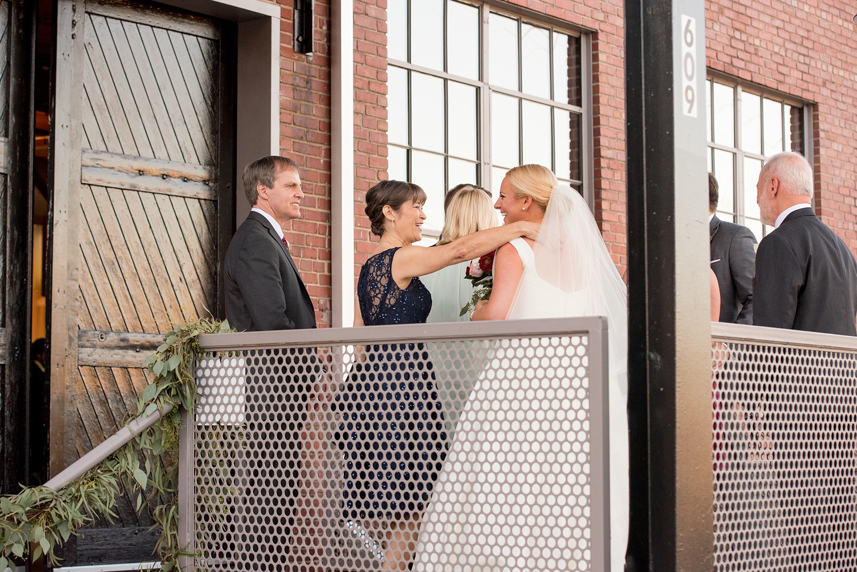 Mikkel Paige Photography photo of a wedding at The Rickhouse, Durham. A picture of the bride and her mother-in-law sharing a hug after the ceremony.