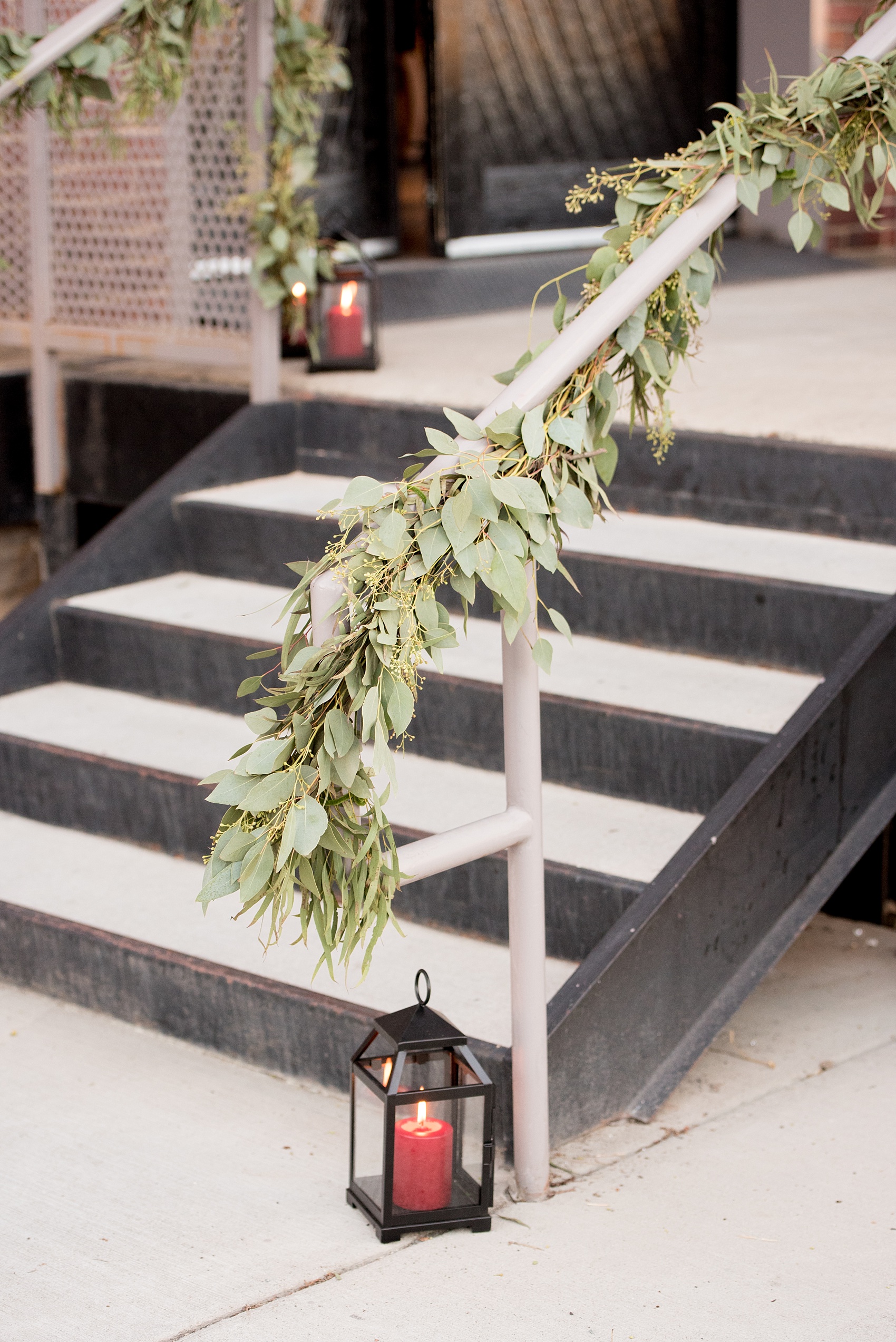 Mikkel Paige Photography photo of a wedding at The Rickhouse, Durham. A picture of the eucalyptus garland placed on the outside stair railing.