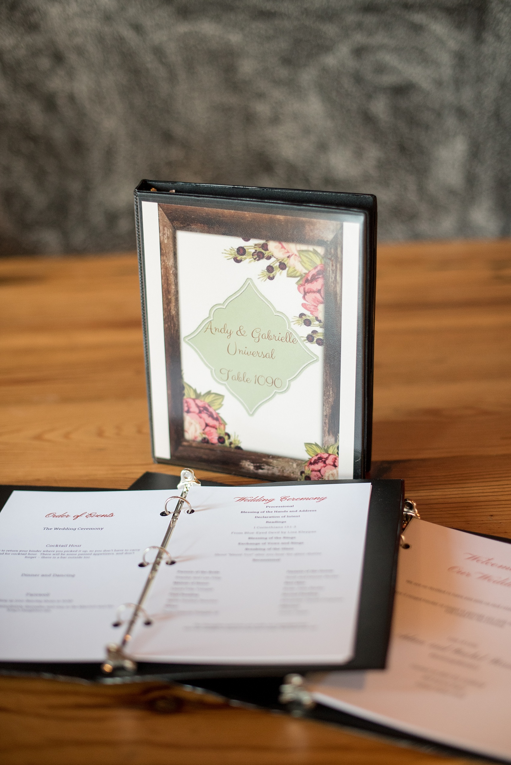 Mikkel Paige Photography photo of a wedding at The Rickhouse, NC. A picture of their escort card alternative binders with information on the evening program and table number meanings.