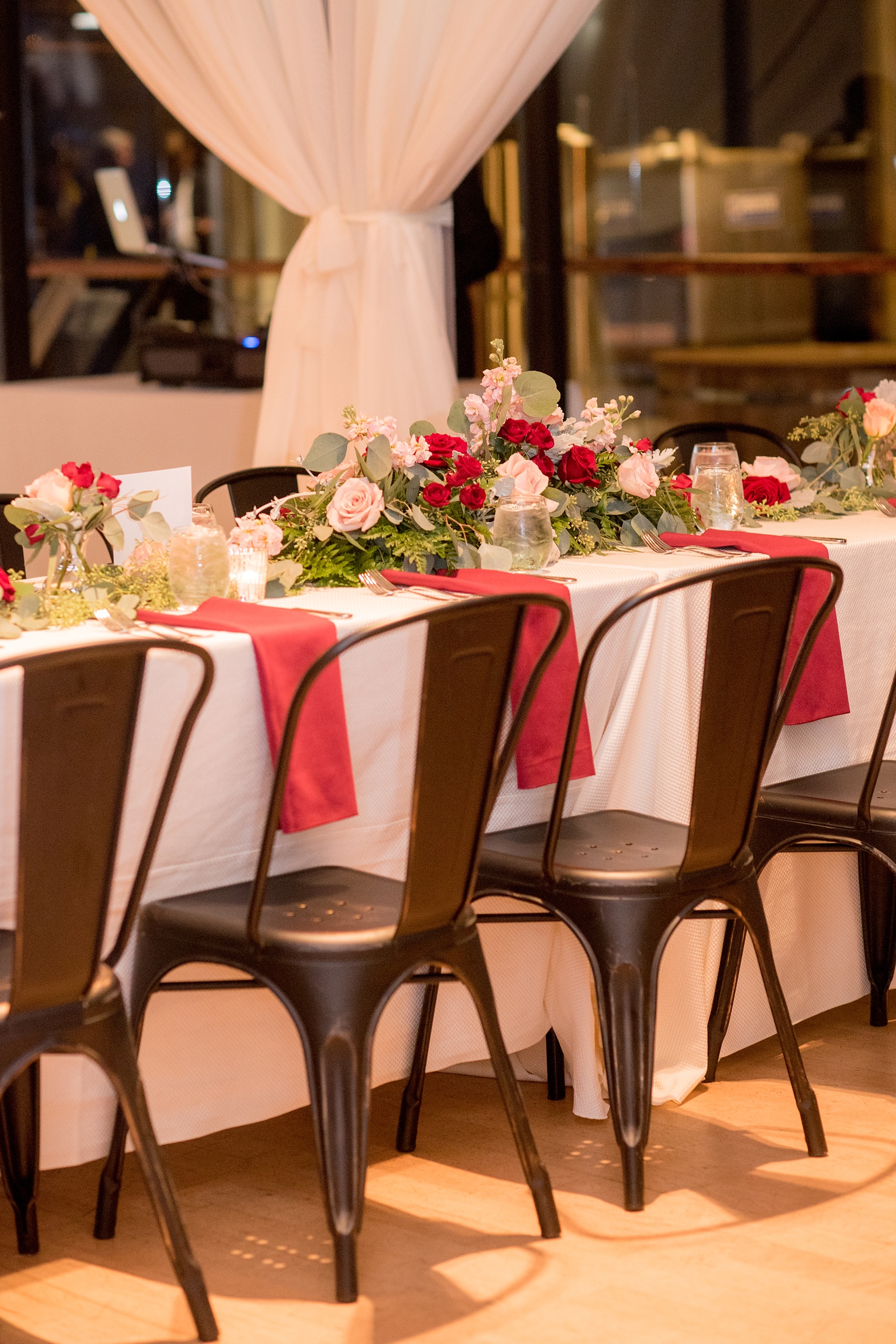 Mikkel Paige Photography photo of a wedding at The Rickhouse, NC. A picture of the rectangular and round mixed tables with burgundy linens and fall flowers and candlelight.