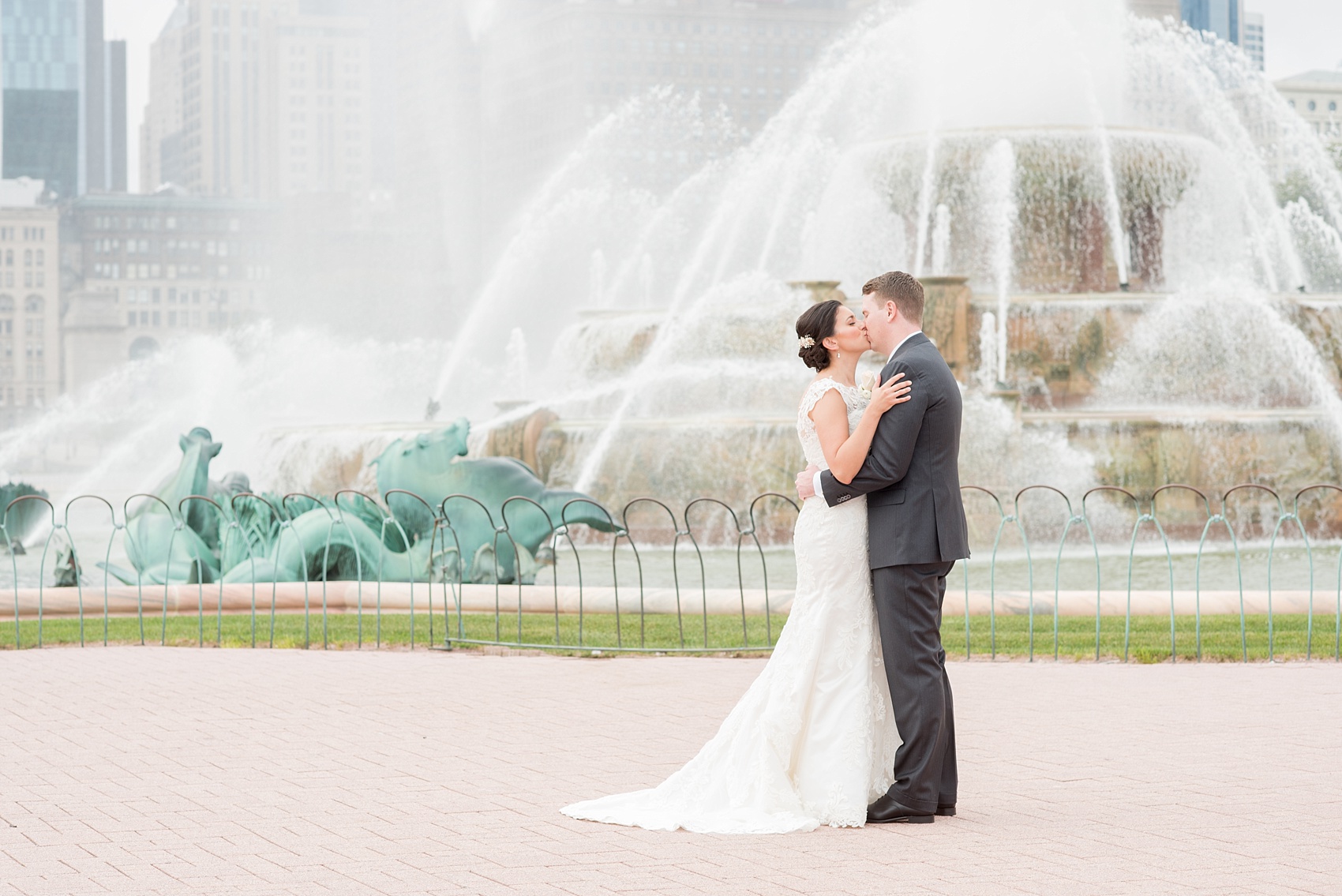 Mikkel Paige Photography photos of a wedding in downtown Chicago at The Rookery, with the bride and groom kissing by Buckingham Fountain.