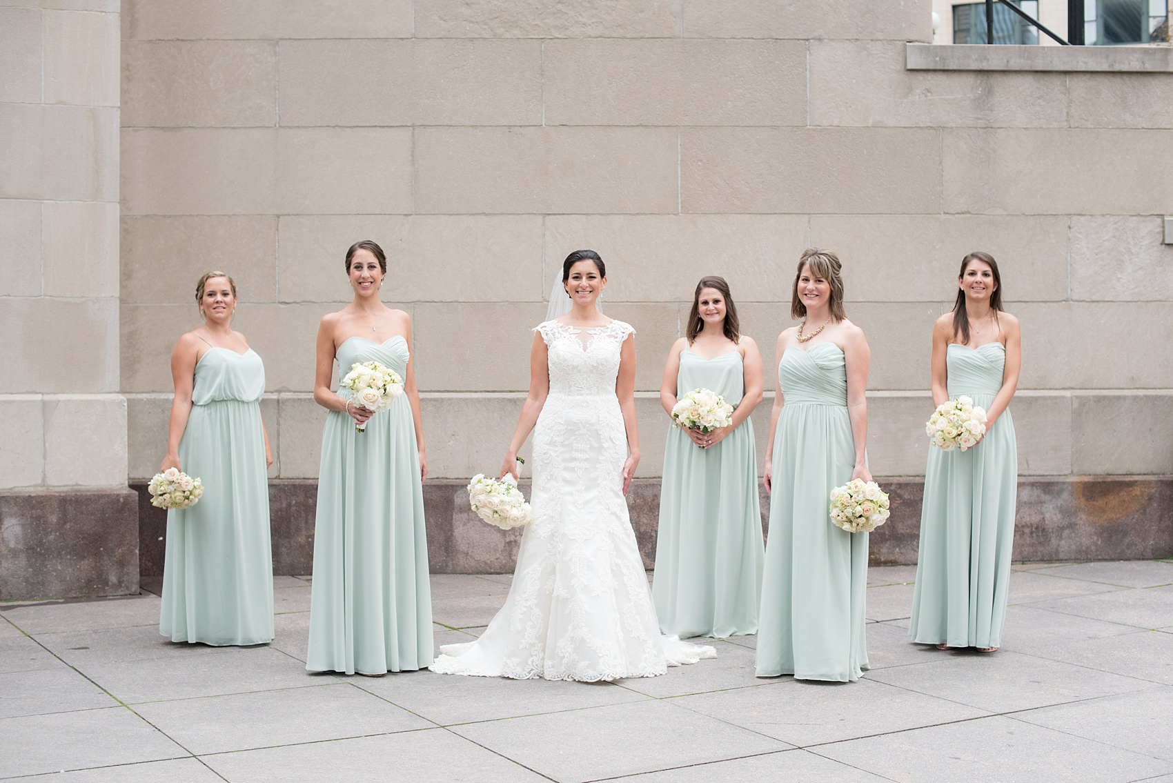 Mikkel Paige Photography photos of a wedding in downtown Chicago at The Rookery. The bride and her bridesmaids in mint green gowns by Alfred Angelo took photos by the waterfront on Riverwalk.