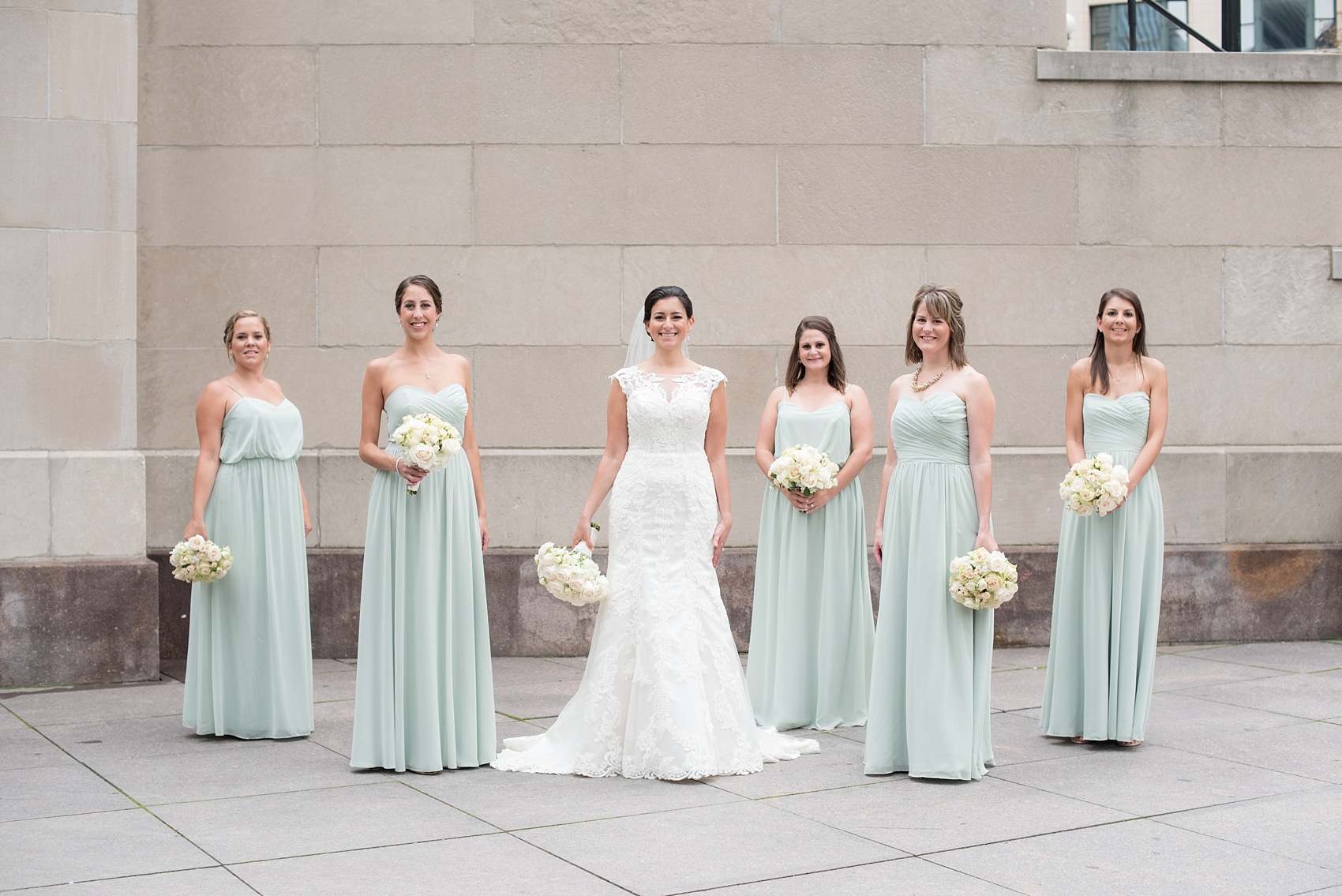 Mikkel Paige Photography photos of a wedding in downtown Chicago at The Rookery. The bride and her bridesmaids in mint green gowns by Alfred Angelo took photos by the waterfront on Riverwalk.