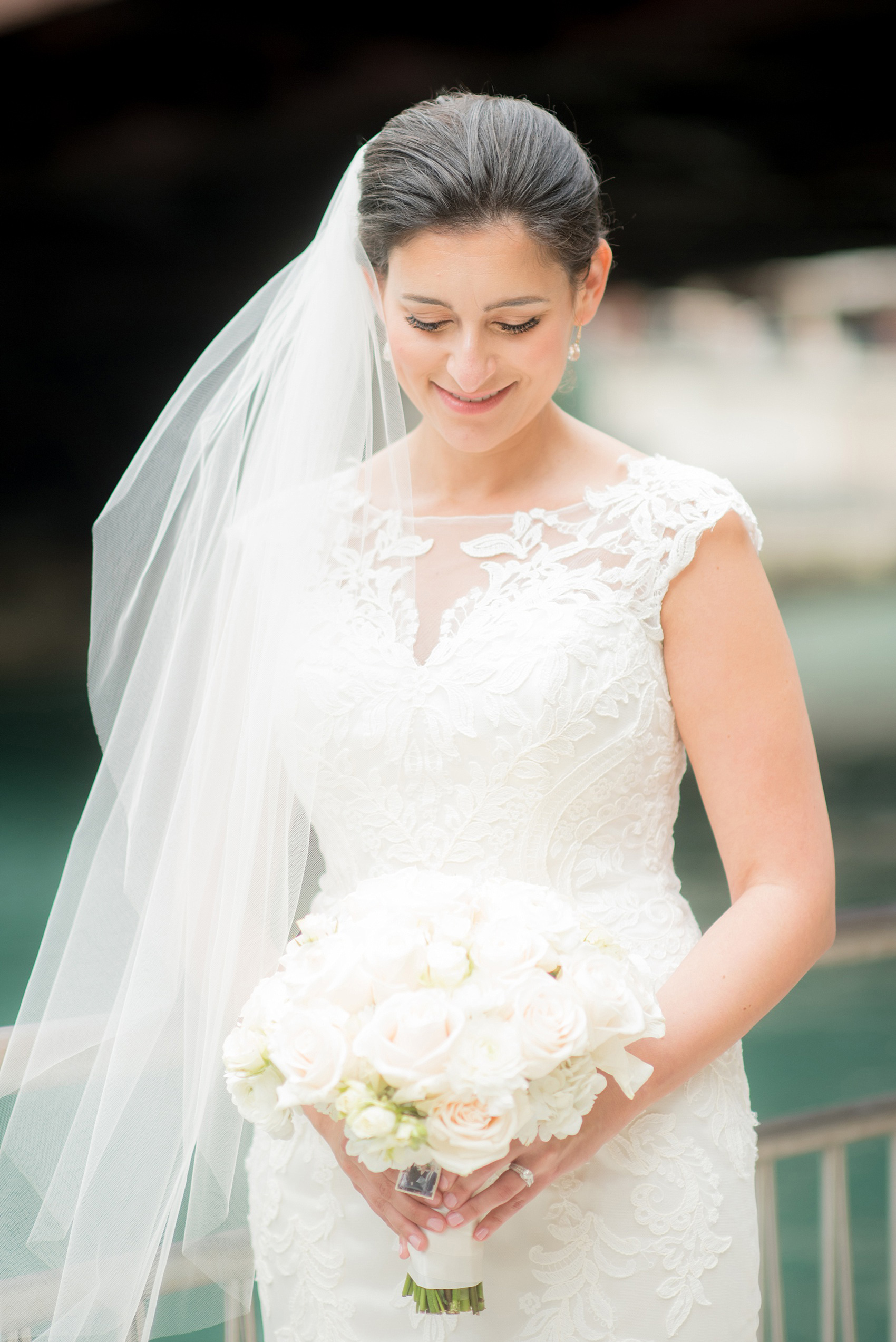 Mikkel Paige Photography photos of a wedding in downtown Chicago at The Rookery. An iconic photo of the bride in a Justin Alexander lace gown with her veil in the wind, holding a rose bouquet.