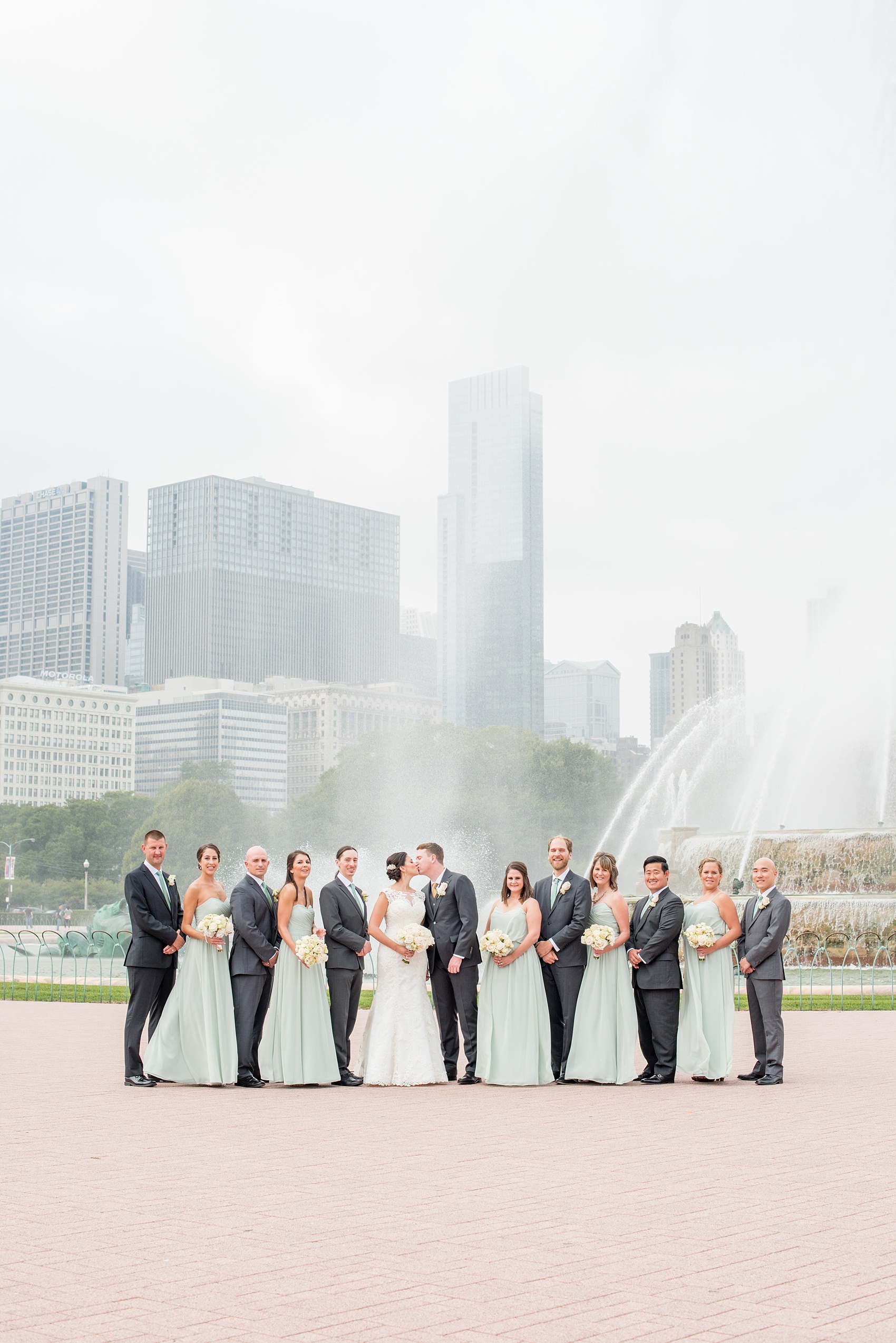 Mikkel Paige Photography photos of a wedding in downtown Chicago at The Rookery. Iconic, unique images of the bridal party in mint green and groomsmen in grey suits for wedding party pictures at Buckingham Fountain.