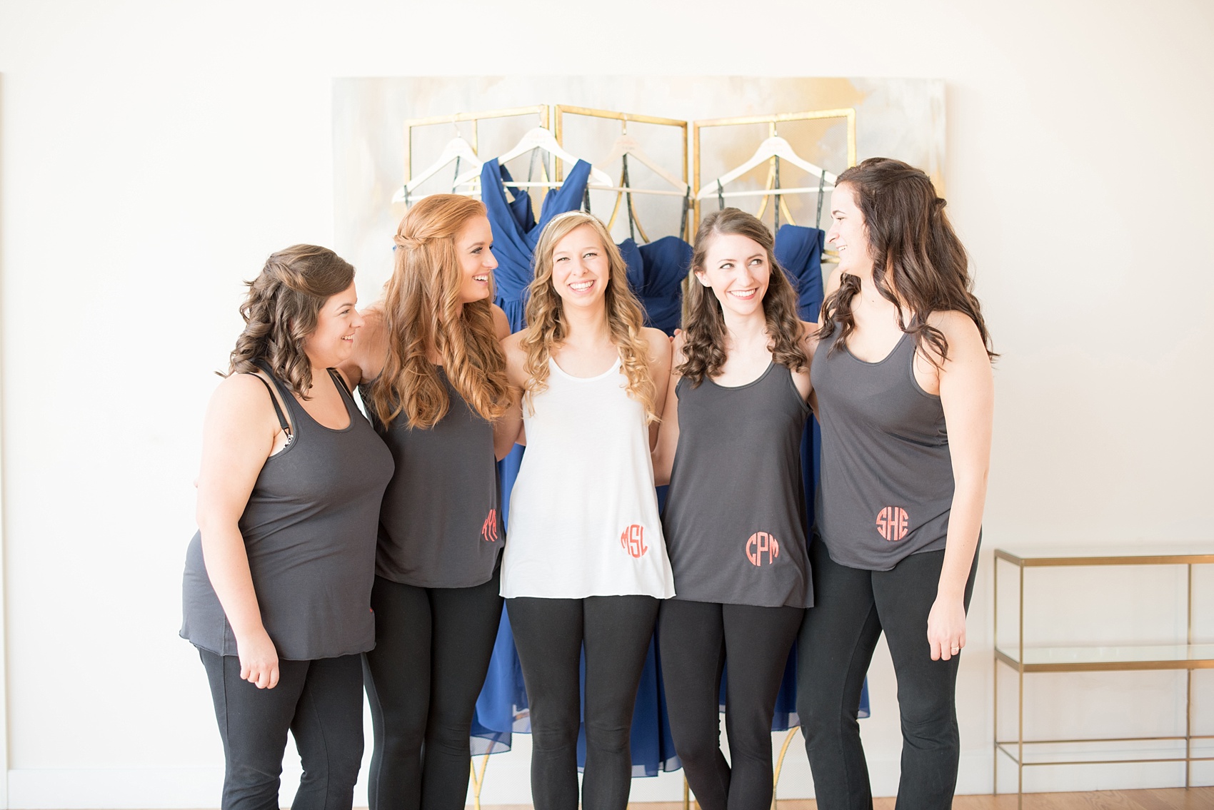 Mikkel Paige Photography photos from a wedding at The Glass Box and Stockroom at 230 in Raleigh. The bridesmaids got ready with custom monogram tank tops and coral TOMS.