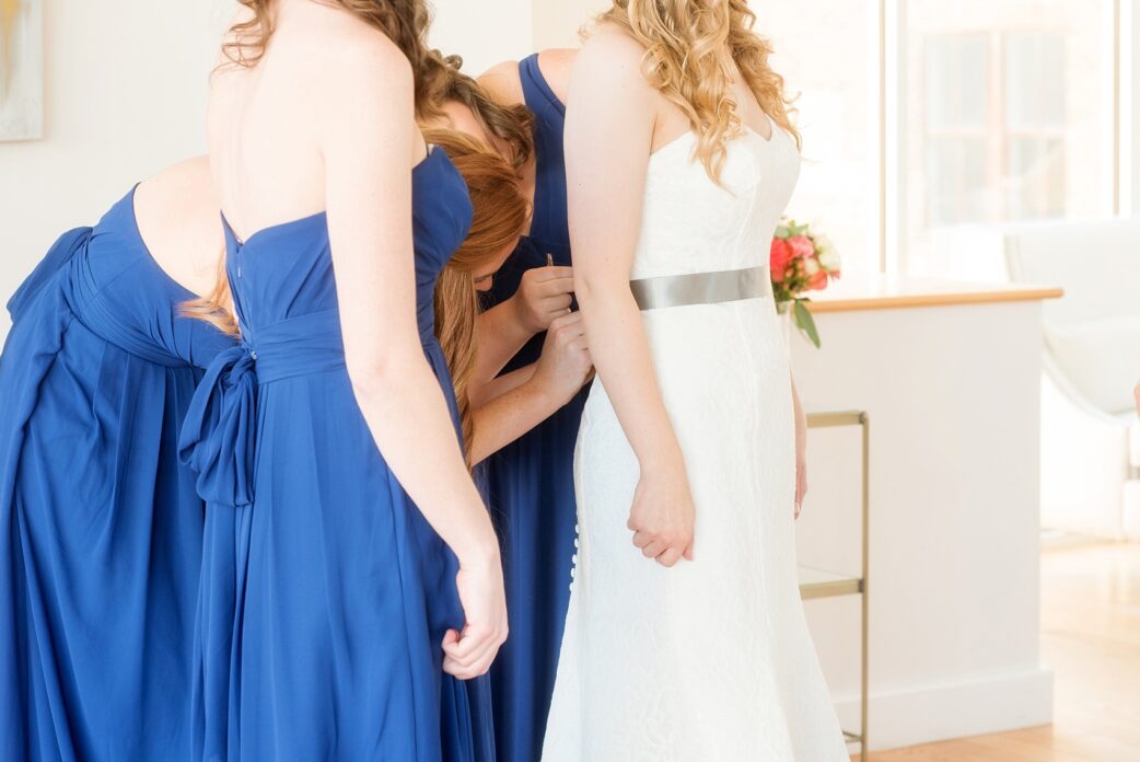 Mikkel Paige Photography photos from a wedding at The Glass Box and Stockroom at 230 in Raleigh. The bride and her bridesmaids in blue gowns prepared for her day.