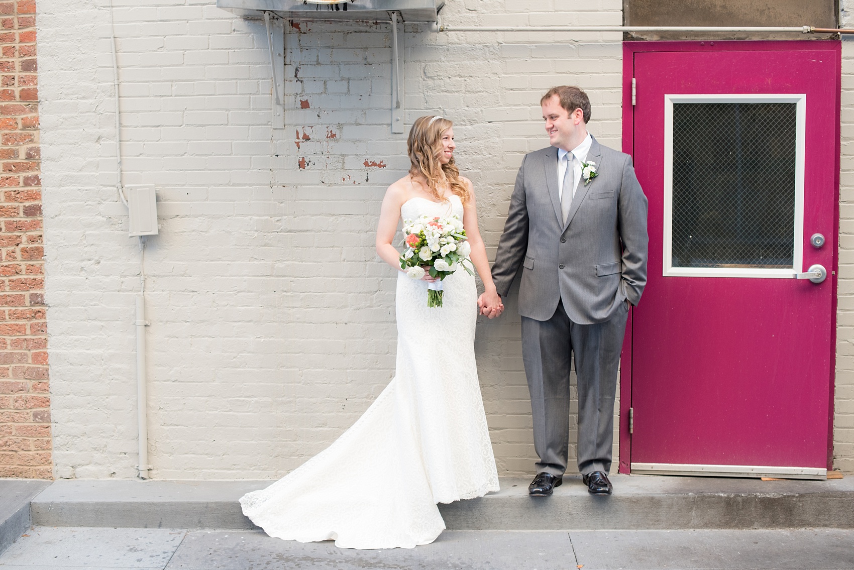 Mikkel Paige Photography photos from a wedding at The Stockroom at 230. A picture of the bride and groom in downtown Raleigh with a hot pink door! 