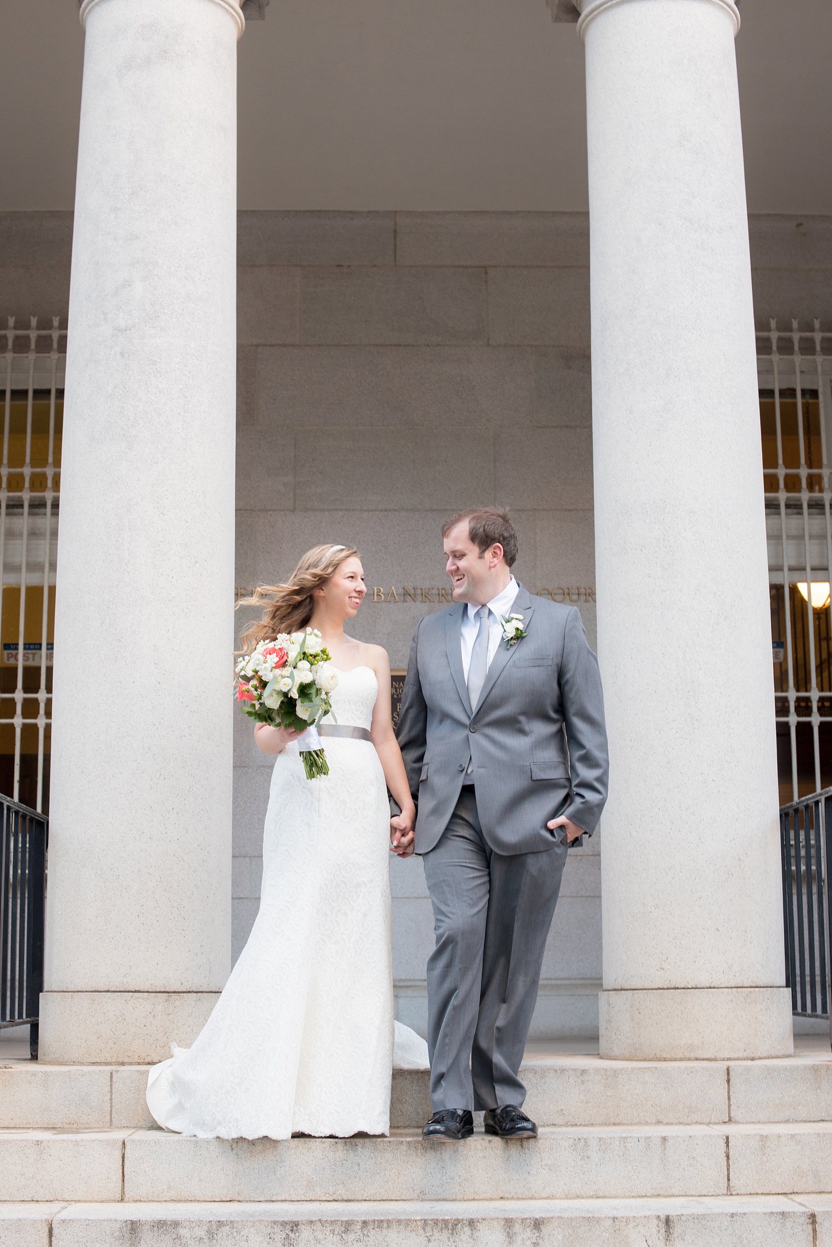 Mikkel Paige Photography photos from a wedding at The Stockroom at 230. A picture of the bride and groom in downtown Raleigh with columns and iconic architecture.