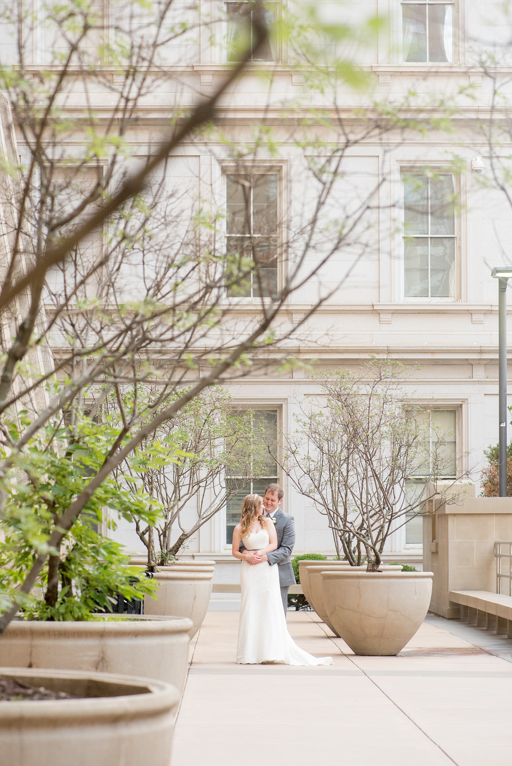 Mikkel Paige Photography photos from a fall wedding at The Stockroom at 230. A picture of the bride and groom in downtown Raleigh with columns and iconic architecture.