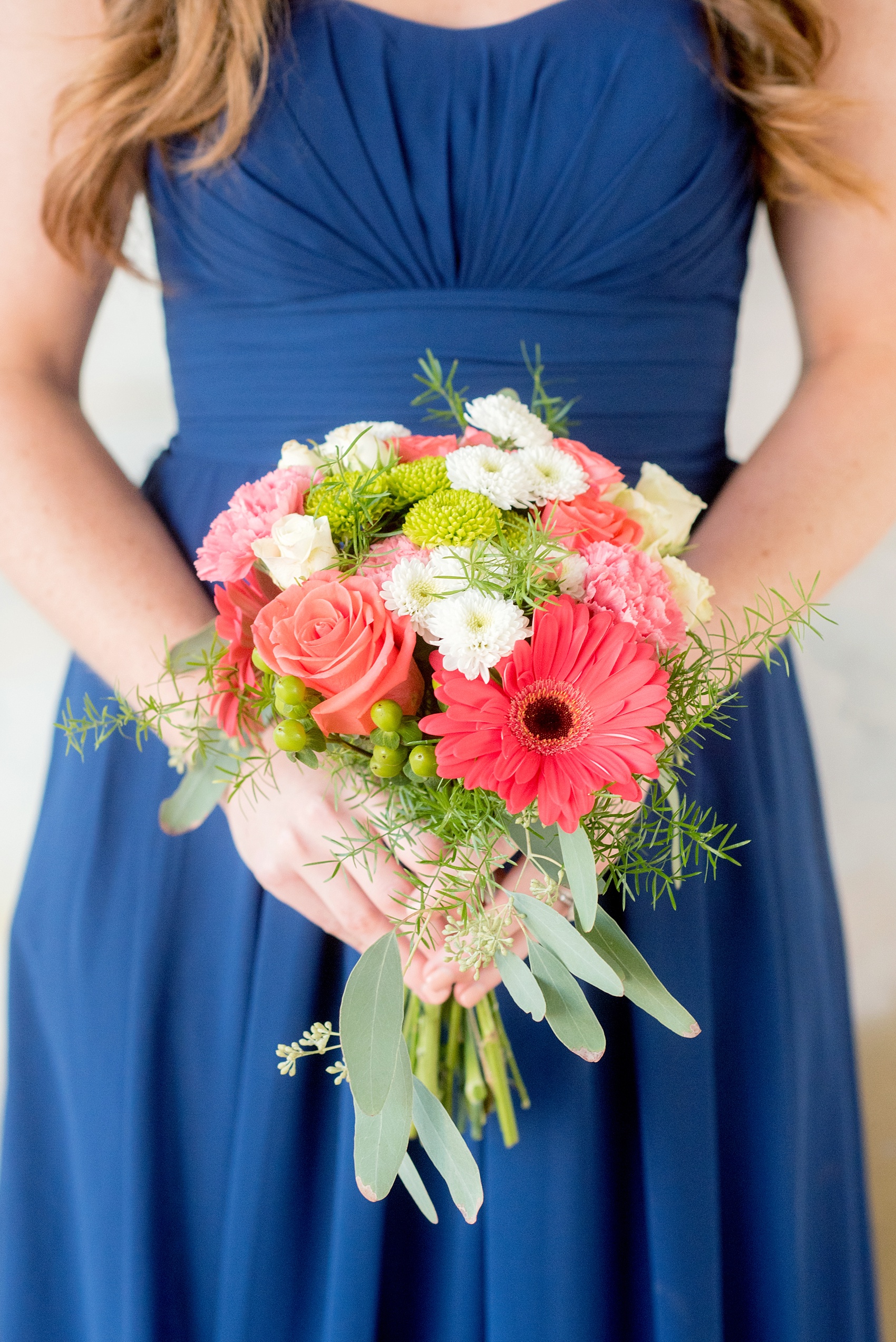 Mikkel Paige Photography photos from a wedding at The Stockroom at 230. A picture of a bridesmaid's fall bouquet of pink, coral and green flowers.