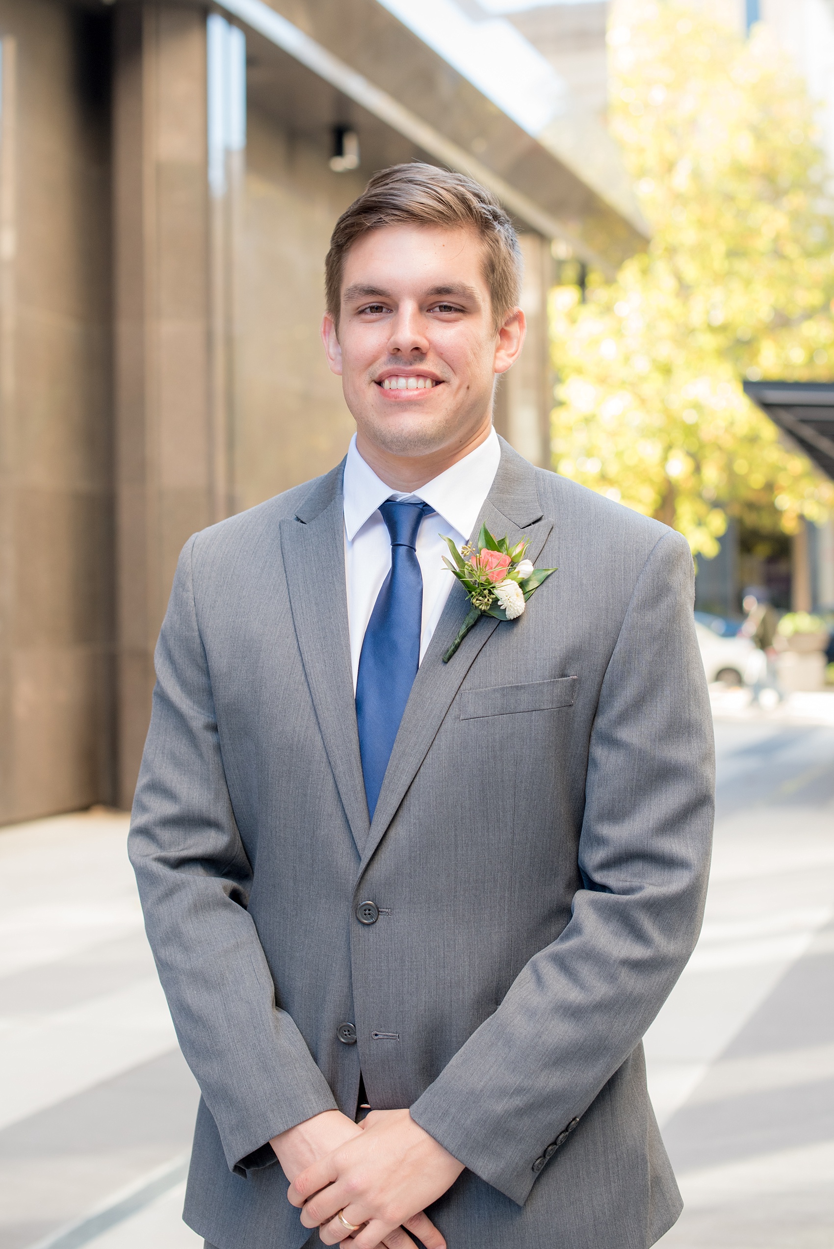 Mikkel Paige Photography photos from a wedding at The Stockroom at 230. A picture of a groomsman in a grey suit with blue tie for a fall wedding in downtown Raleigh.