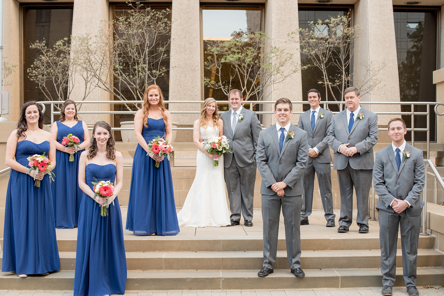 Mikkel Paige Photography photos from a fall wedding at The Stockroom at 230. A unique picture of the bride, groom and their wedding party in downtown Raleigh. The bridesmaids wore cobalt blue gowns.