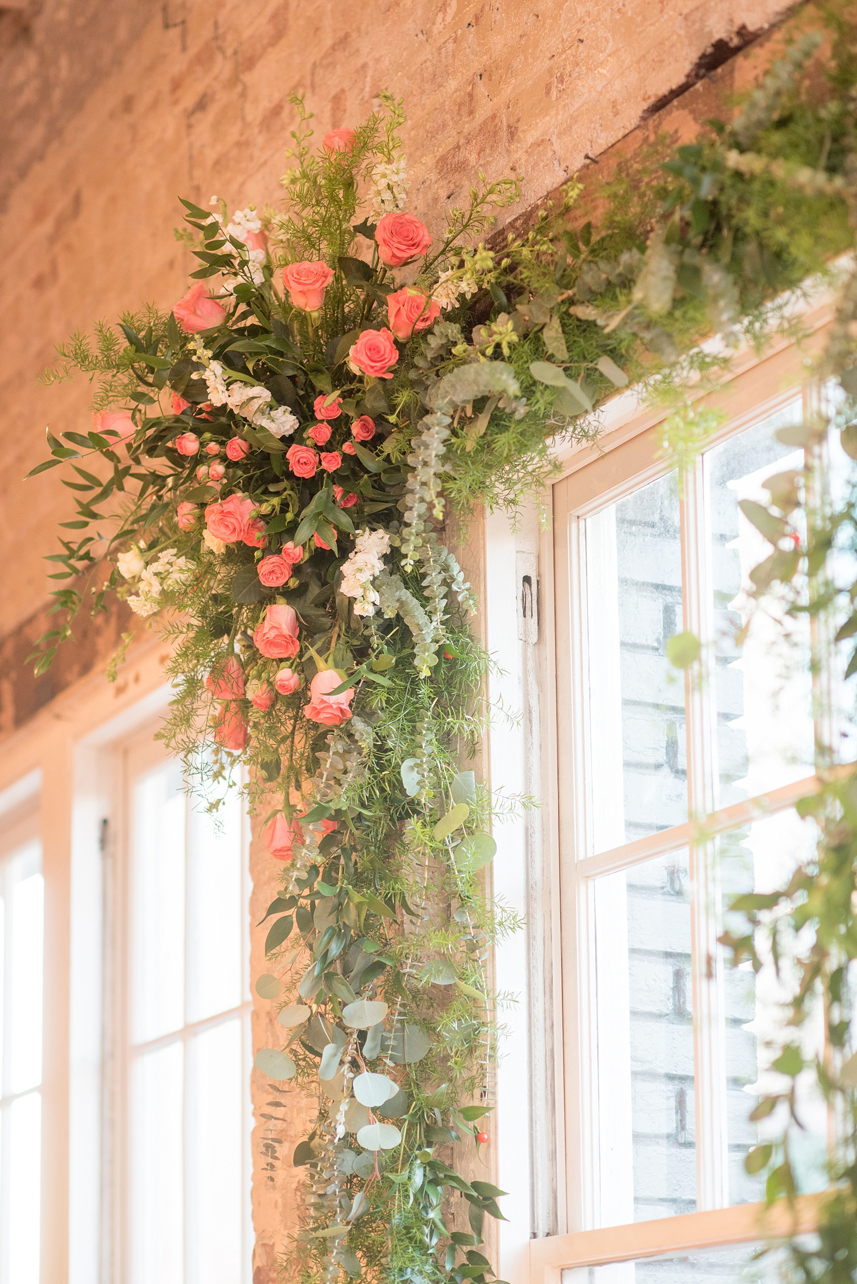 Mikkel Paige Photography photos from The Stockroom at 230 in downtown Raleigh. A picture of the floral arch around a window for the ceremony.