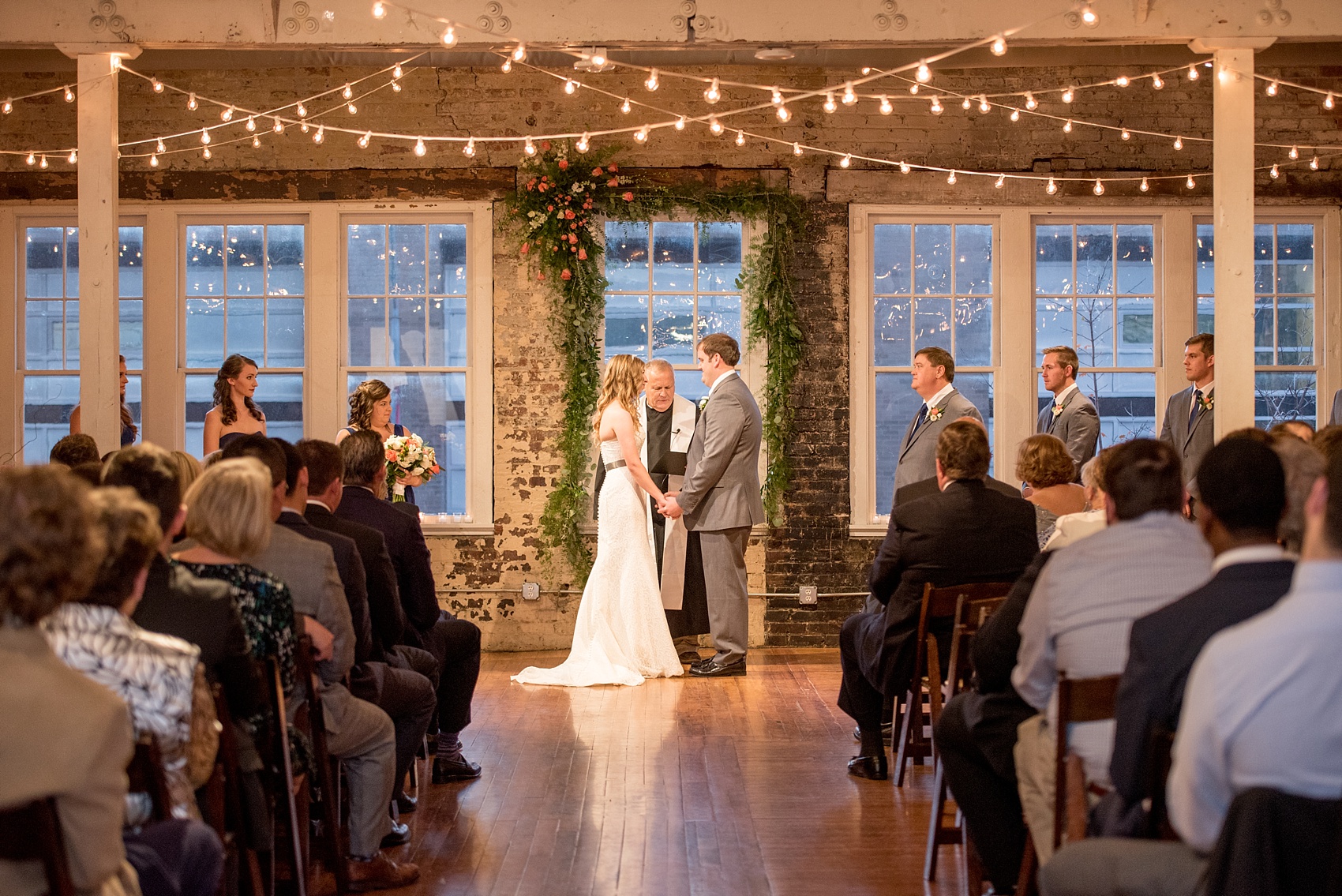 Mikkel Paige Photography photos from The Stockroom at 230 in downtown Raleigh. A picture of the ceremony with market lights.