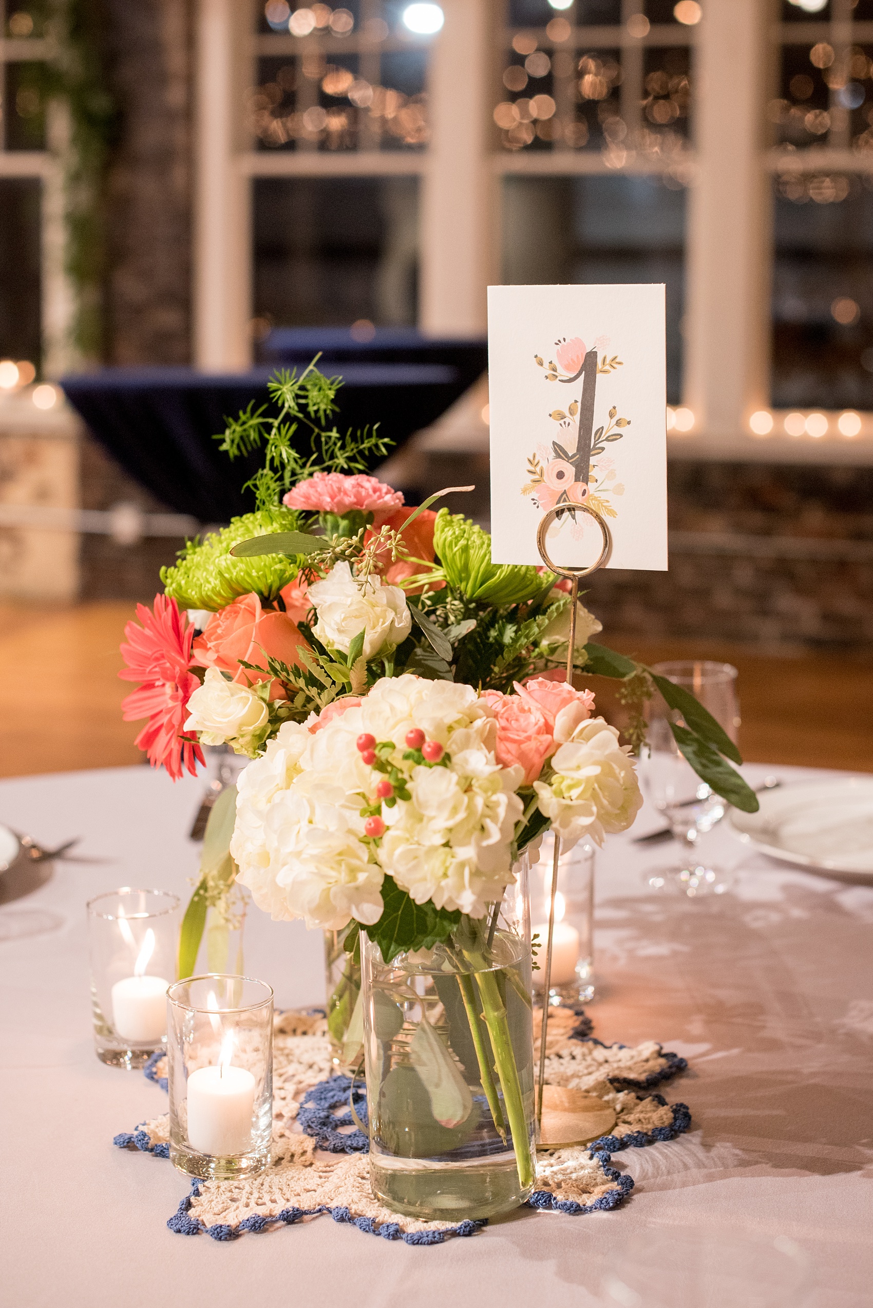 Mikkel Paige Photography photos from a wedding reception at The Stockroom at 230 in Raleigh. A picture of the centerpieces with green, white and coral flowers and Rifle Paper Co table numbers.