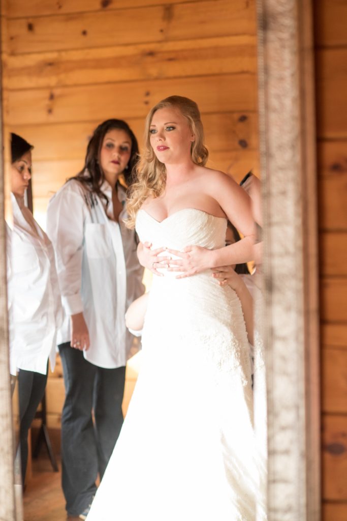 Mikkel Paige Photography photos of a wedding at The Barn at Valahalla in Chapel Hill, NC. The bride prepares for her first look in a rustic room.