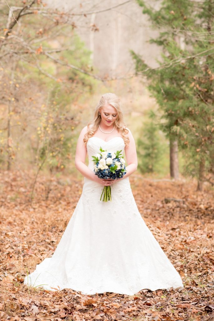 Mikkel Paige Photography photos of a wedding at The Barn at Valahalla in Chapel Hill, NC. An iconic picture of the bride in her lace sweetheart neck dress in the woods amongst fall leaves.