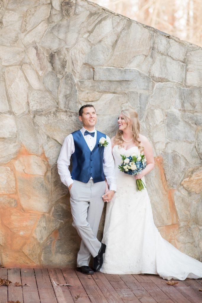 Mikkel Paige Photography photos of a wedding at The Barn at Valahalla in Chapel Hill, NC. A candid picture of the bride and groom against a stone wall during their winter day.