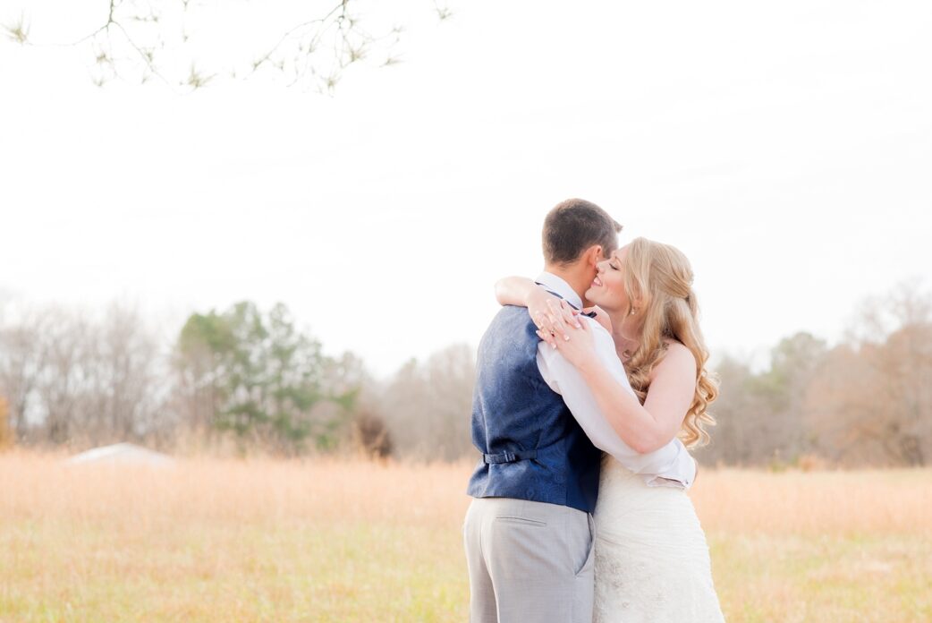 Mikkel Paige Photography photos of a wedding at The Barn at Valahalla in Chapel Hill, NC. The bride whispers to her groom in this iconic picture by autumn grasses on the open southern property.