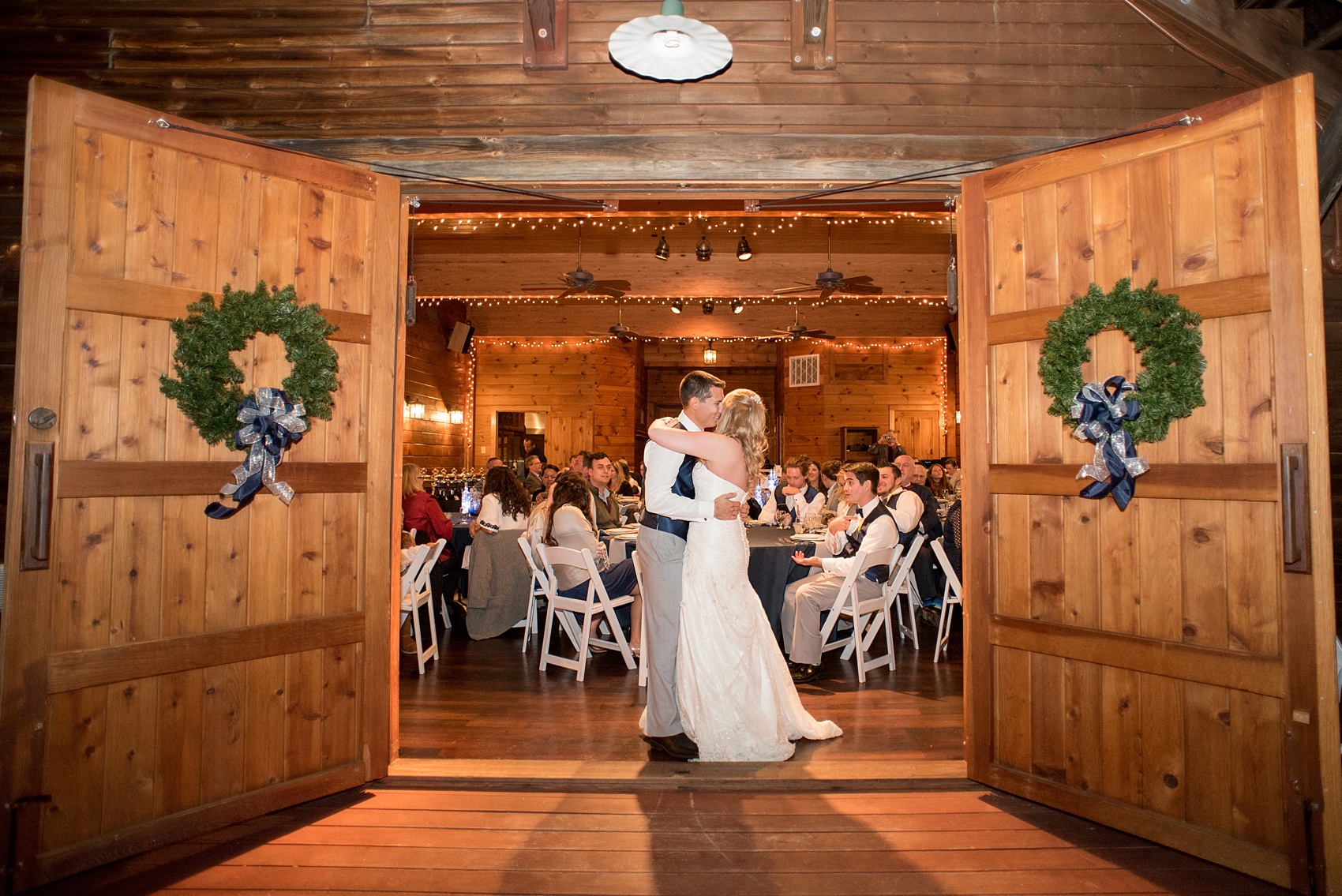 Mikkel Paige Photography photos of a wedding at The Barn at Valahalla in Chapel Hill, NC. A picture of the bride and groom's first dance between barn door and string lights.