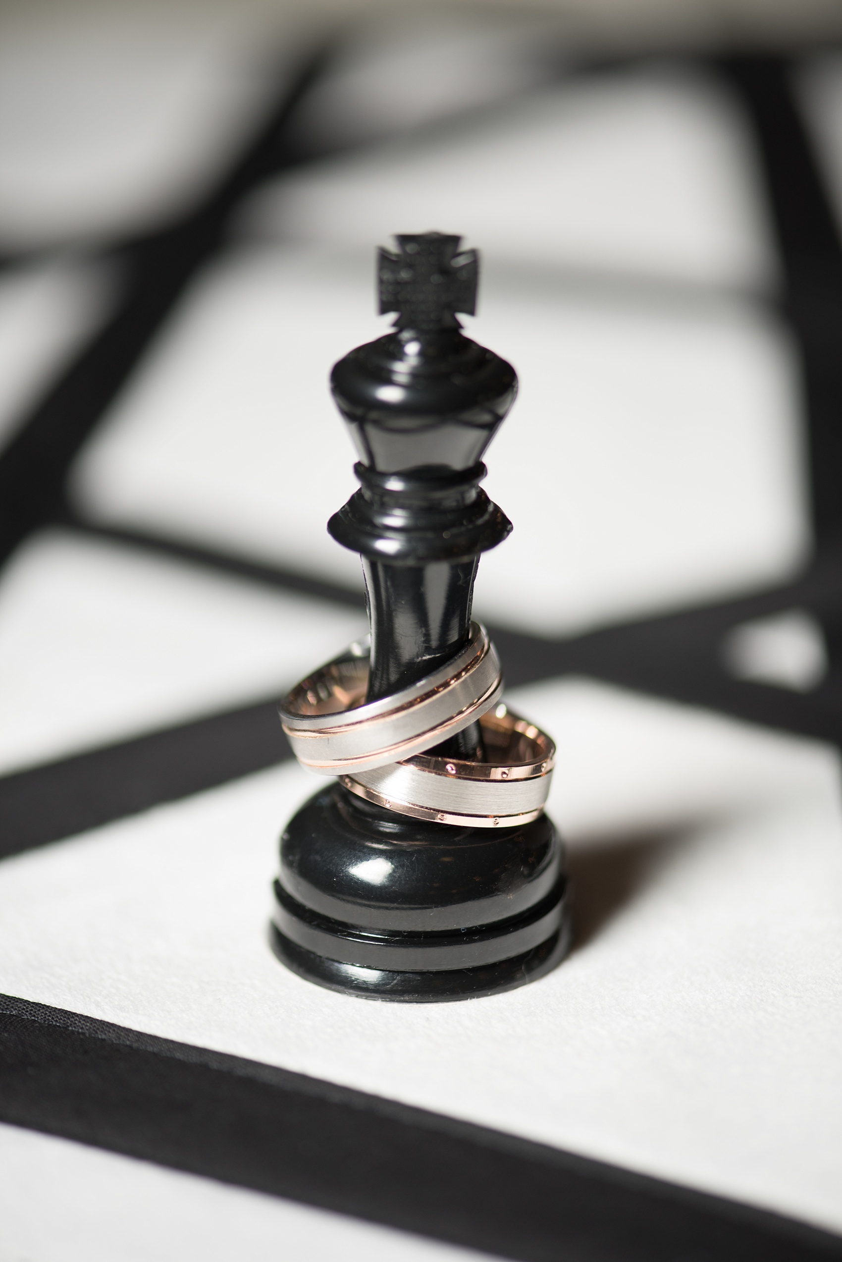 Mikkel Paige Photography pictures of a Raleigh, NC wedding at All Saints Chapel. Gay inspiration with two-tone gold rings on a chess piece.