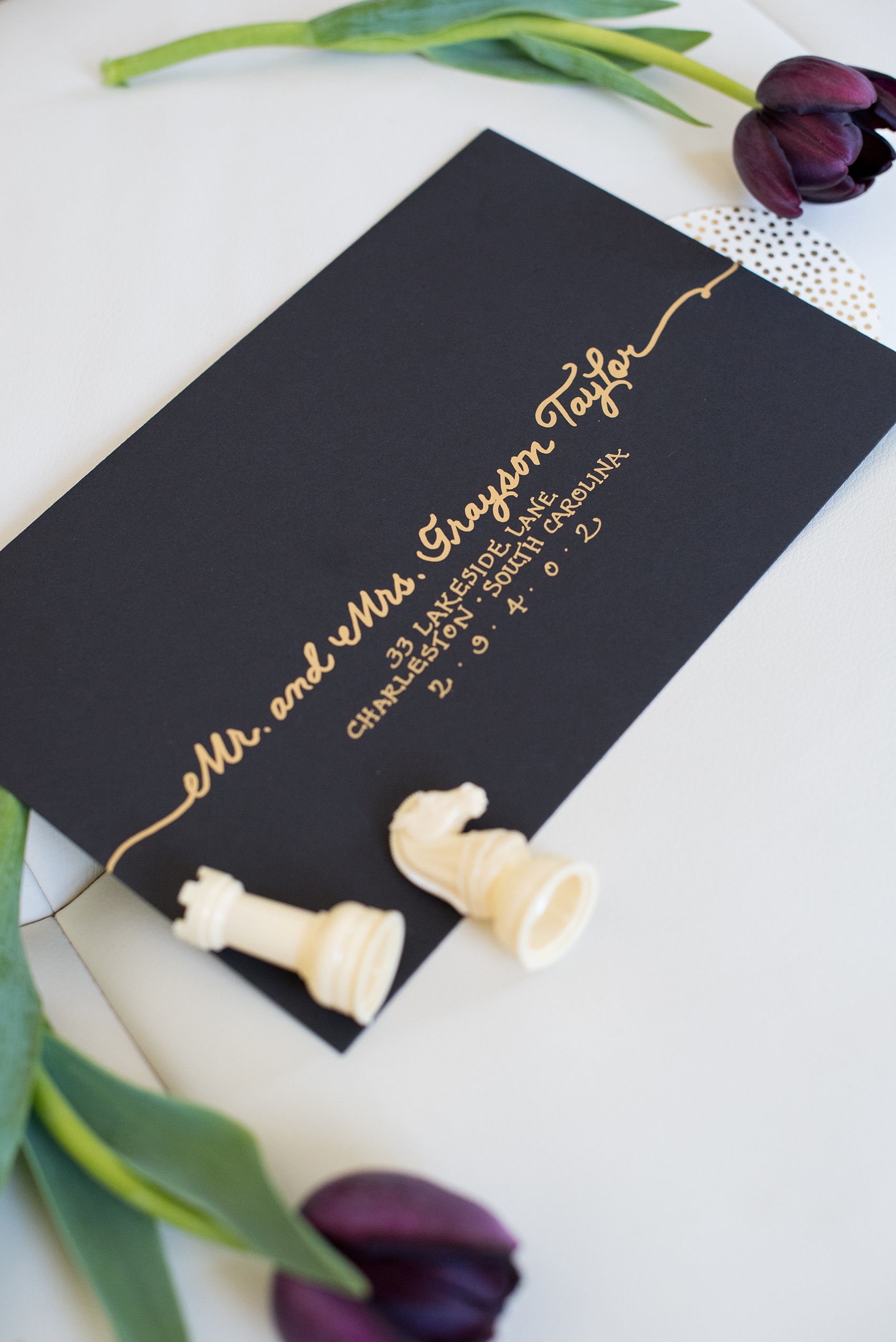 Mikkel Paige Photography pictures of a Raleigh, NC wedding at All Saints Chapel. Gay inspiration with a gold and black custom envelope and chess pieces.