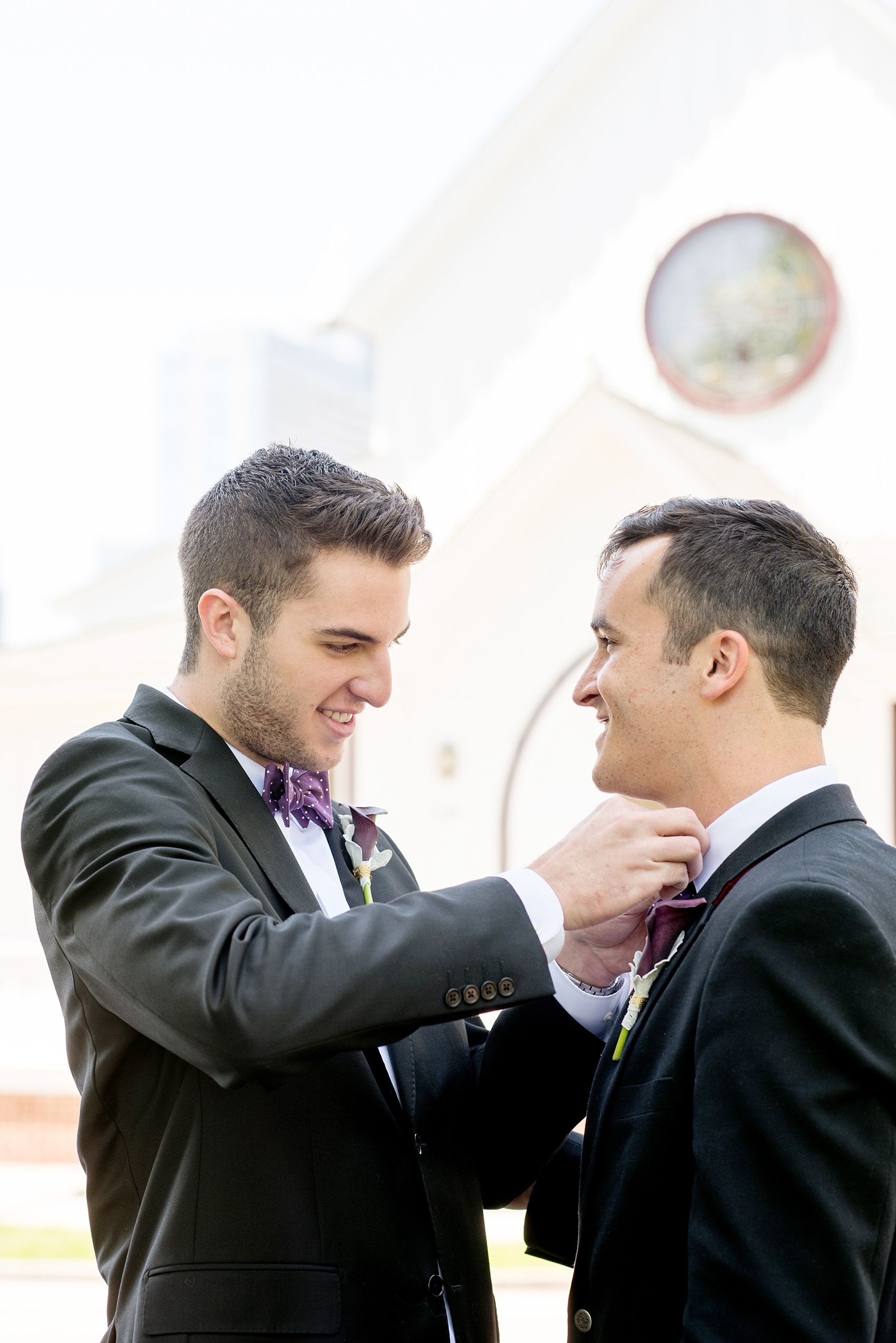 Mikkel Paige Photography pictures of a Raleigh, NC gay wedding at All Saints Chapel. The two grooms help tie bow ties.