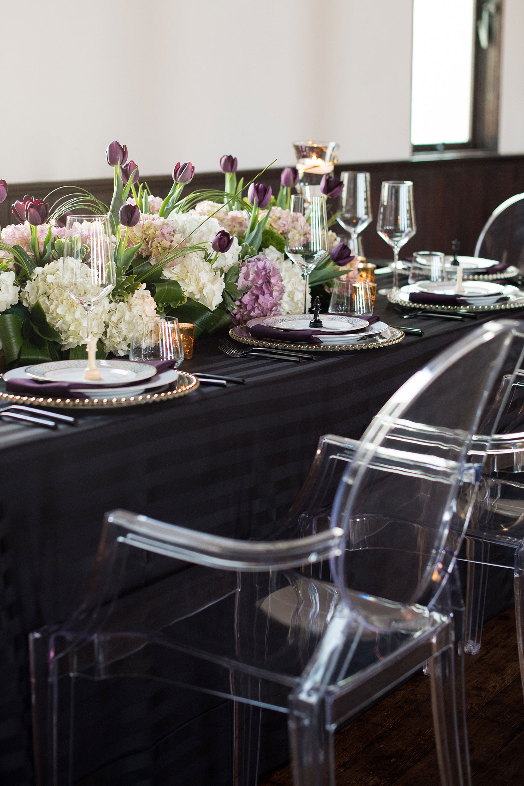 Mikkel Paige Photography pictures of a gay All Saints Chapel wedding in Raleigh, NC. Purple, black and white inspiration with modern ghost chairs in a historic venue.