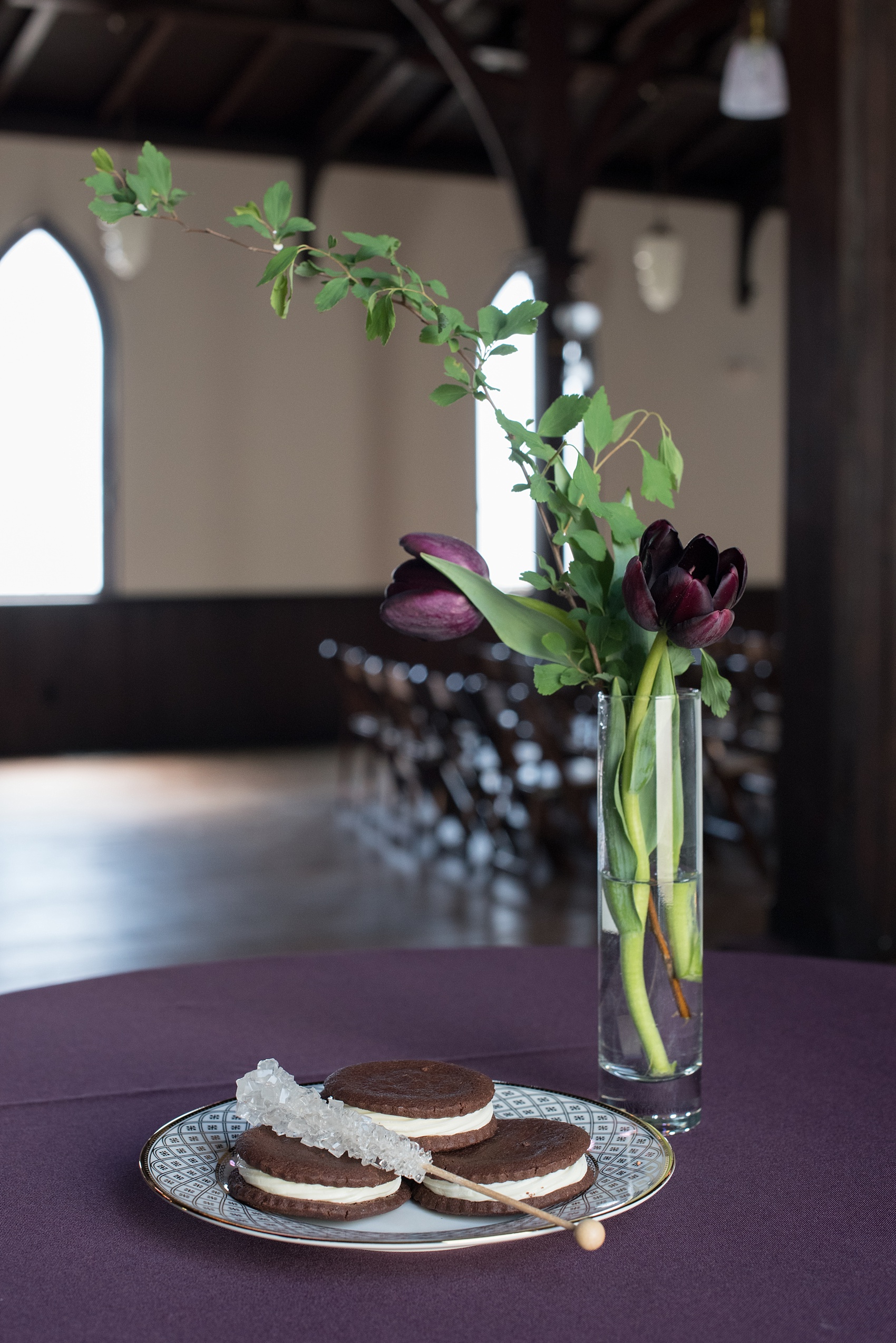 Mikkel Paige Photography pictures of a gay All Saints Chapel wedding in Raleigh, NC. Purple, black and white inspiration with a modern twist and gold accents. Chocolate whoopie pie desserts are accented by clear rock candy sticks.
