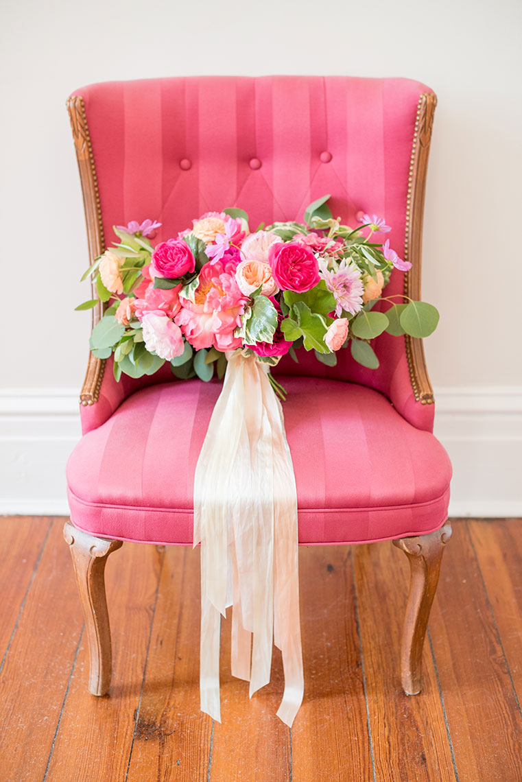 Mikkel Paige Photography photos of a wedding at Merrimon-Wynne House in downtown Raleigh. Picture of the bride's colorful summer bouquet on a pink chair.