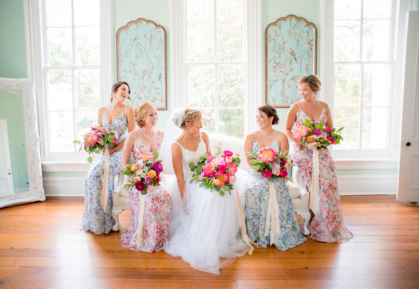 Mikkel Paige Photography photos of a wedding at Merrimon-Wynne House in downtown Raleigh. Picture of the bride with her bridesmaids in patterned floral maxi dresses.