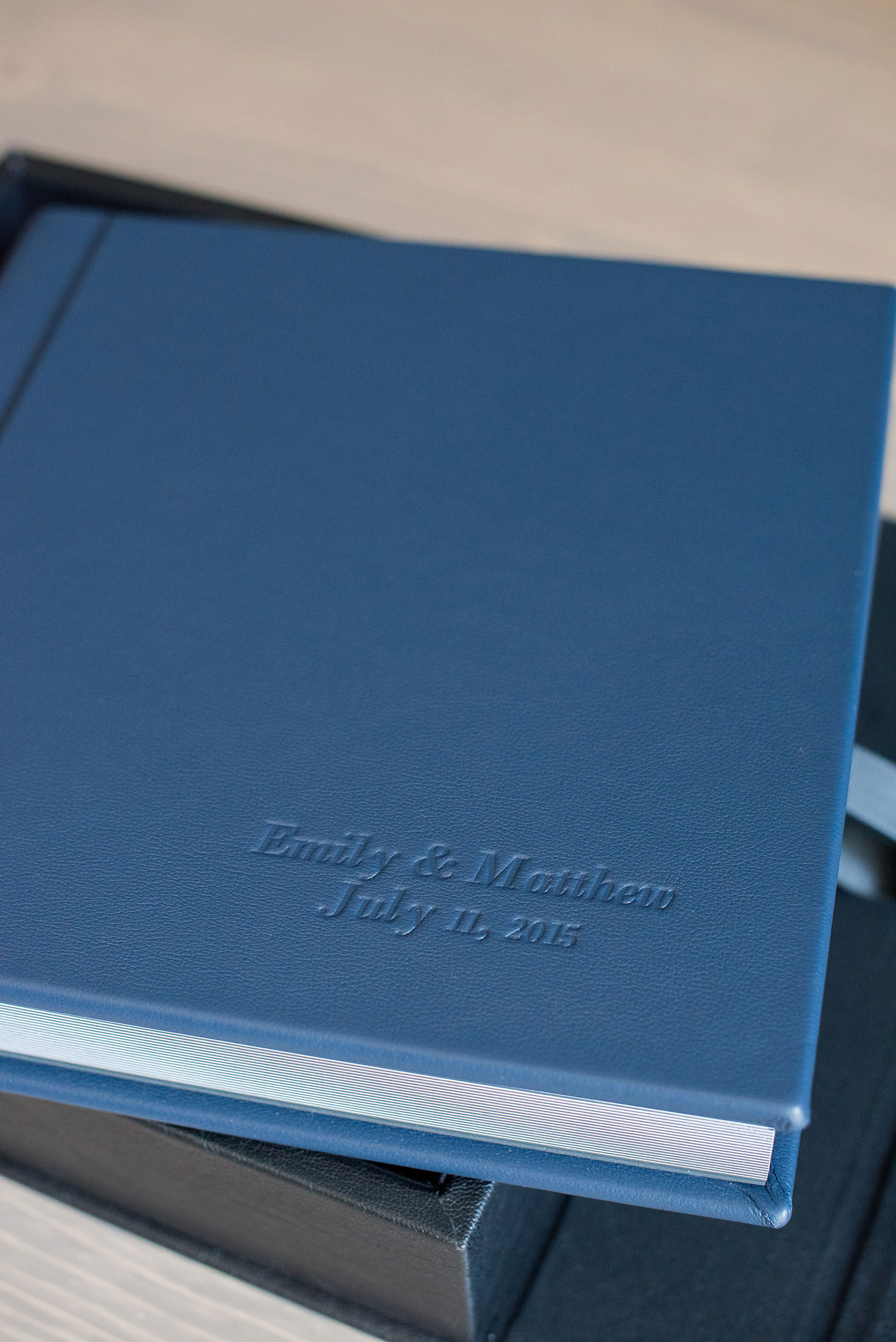 Mikkel Paige Photography photos of a navy blue leather Madera wedding album. Pearl River Hilton wedding - album has debossing on the cover. 