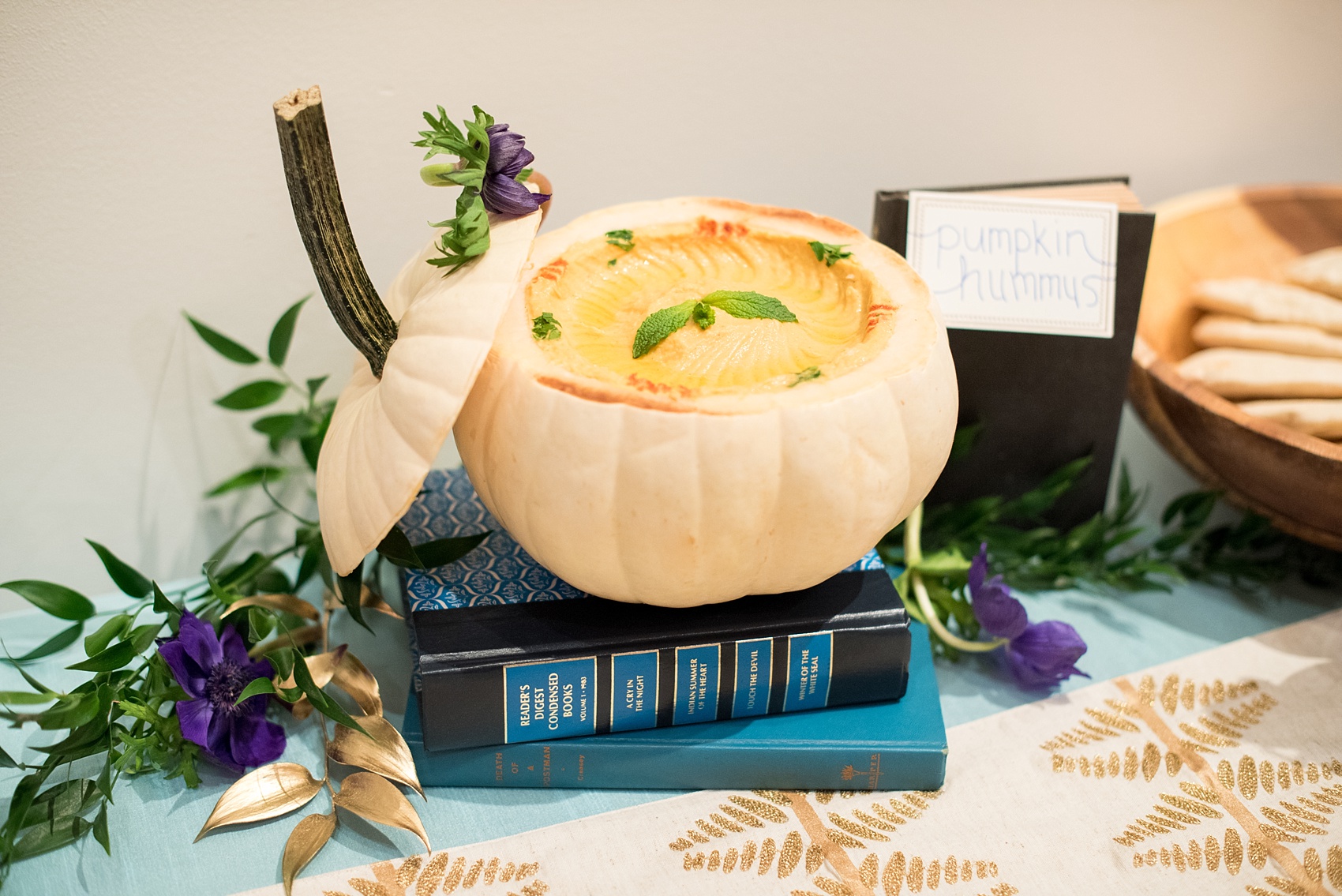 Mikkel Paige Photography photos at The Glass Box in downtown Raleigh. Pumpkin hummus served inside a white pumpkin on top of a stack of vintage books.