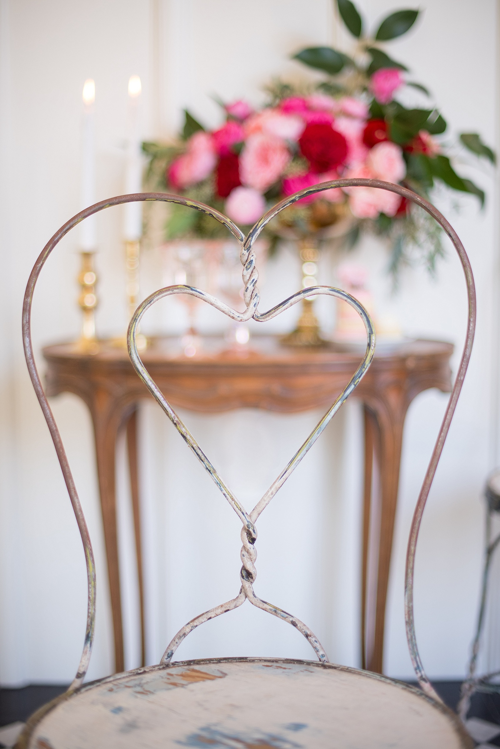 All Saints Chapel Raleigh bridal photos with an inspirational tea for Valentine's Day with pink and red flowers and heart chairs from Greenhouse Picker Sisters.