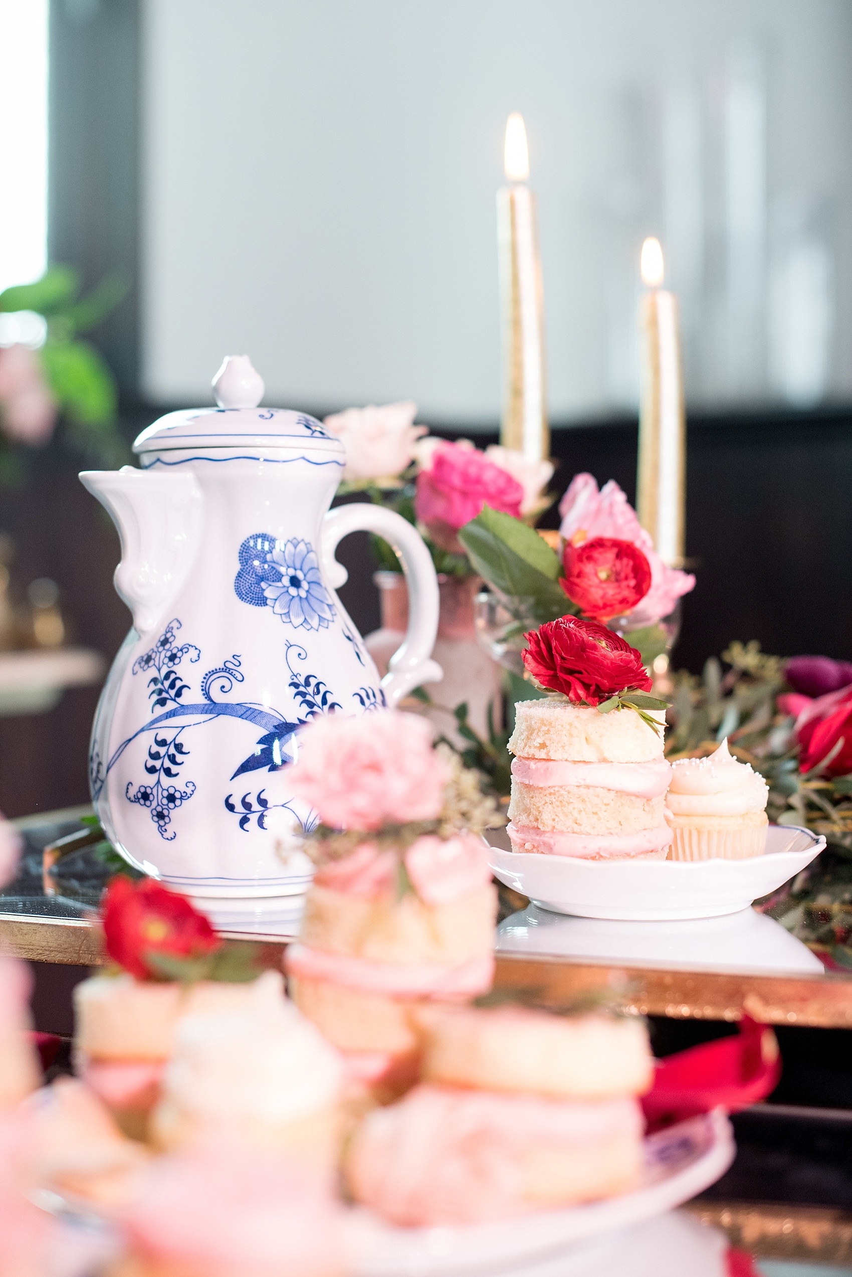 All Saints Chapel Raleigh bridal photos with an inspirational tea for Galentine's Day with pink and red mini cakes and white and blue tea set.