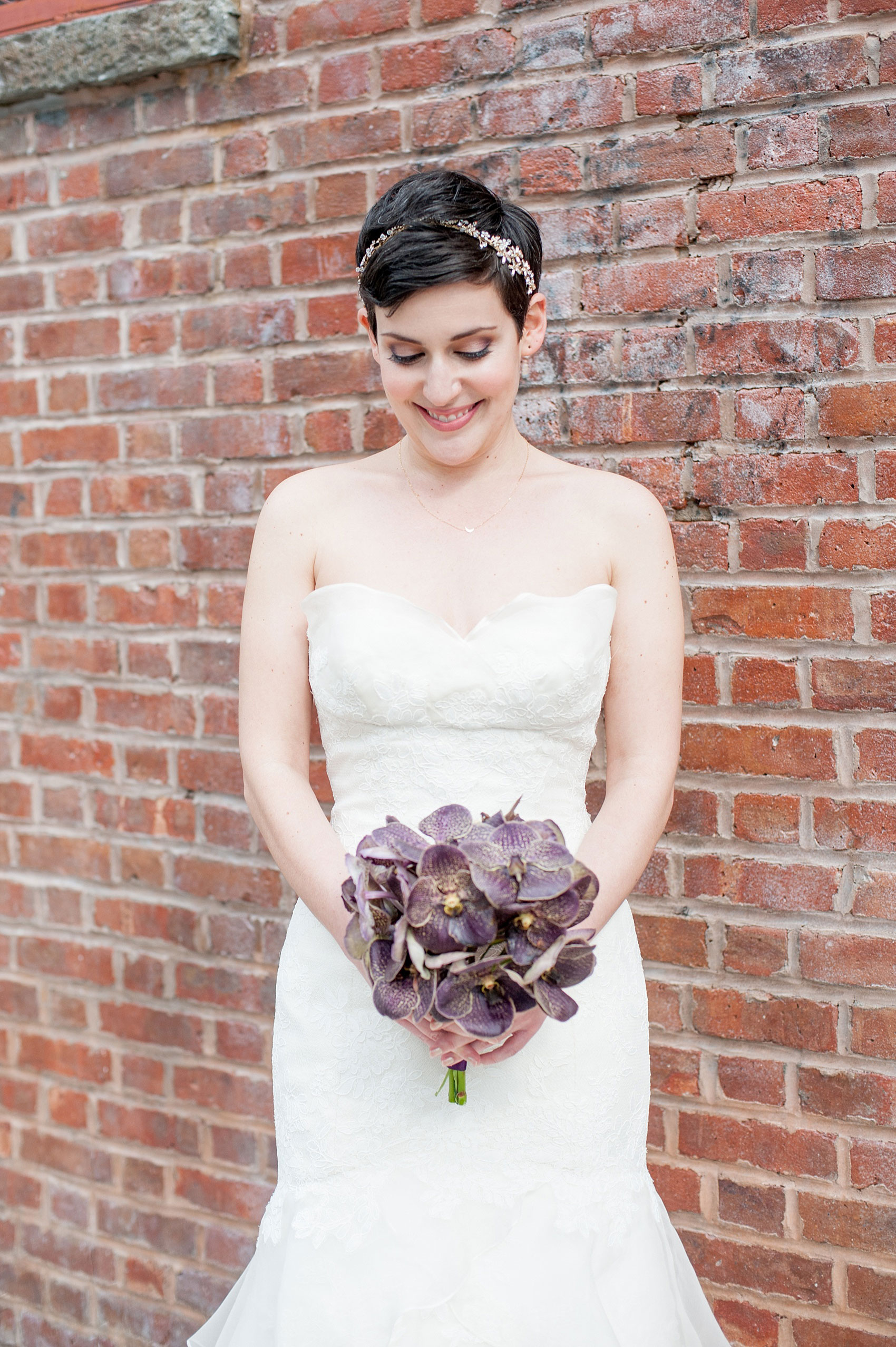 Mikkel Paige Photography Brooklyn Winery wedding photos. Picture of the bride in her strapless lace gown holding her unique bouquet of dark purple orchids.