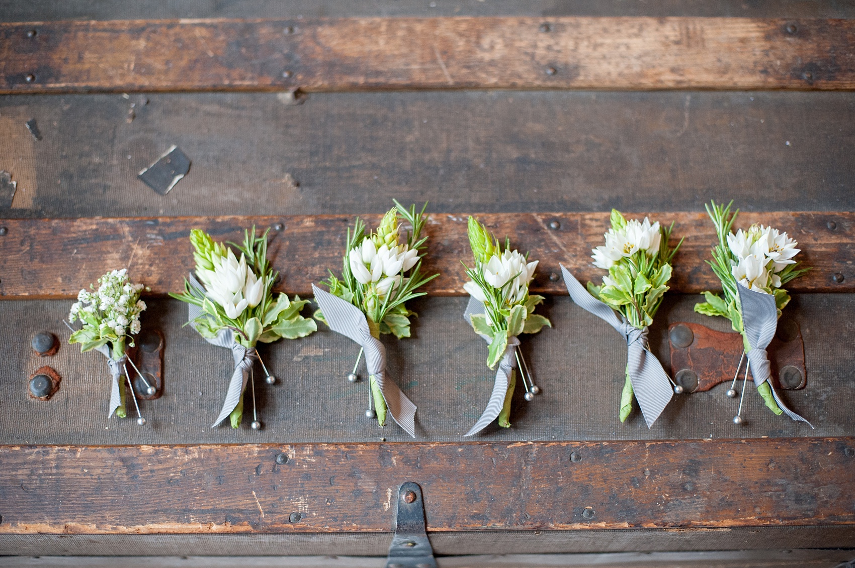 Mikkel Paige Photography Brooklyn Winery wedding photos. Detail picture of the wildflower boutonnieres tied with grey ribbon.