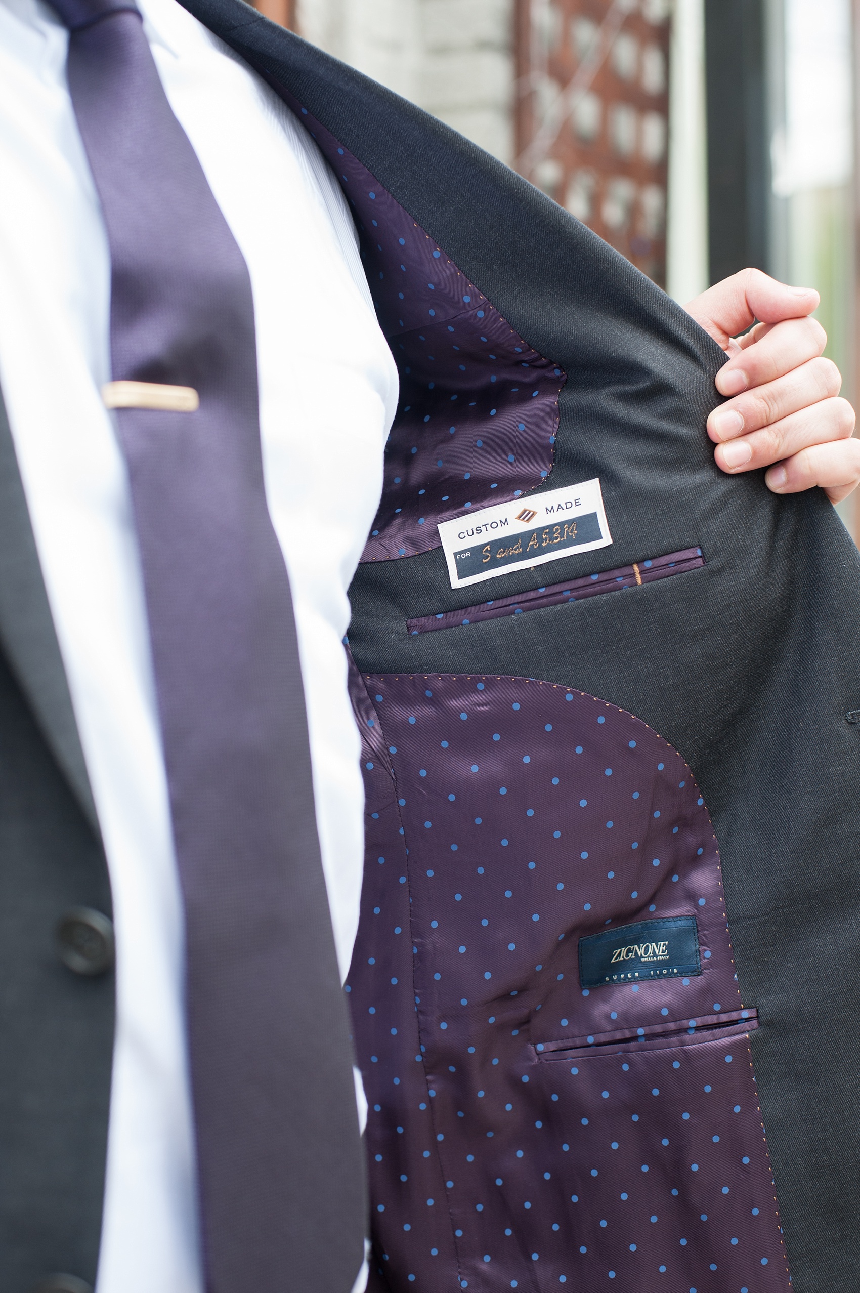 Mikkel Paige Photography Brooklyn Winery wedding photos. Detail picture of the groom in a custom suite with deep purple jewel tone tie and polka dot lining.