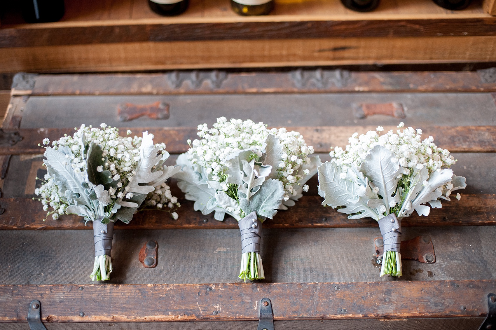 Mikkel Paige Photography Brooklyn Winery wedding photos. Detail picture of the bridesmaids bouquets of Dusty Miller and Baby's Breath flowers tied with grey ribbon.