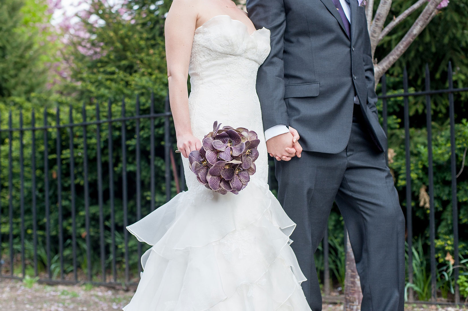 Mikkel Paige Photography Brooklyn Winery wedding photos. Picture of the bride and groom holding hands and her unique dark purple orchid bouquet.