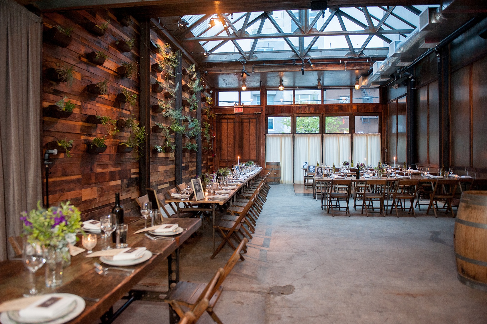 Mikkel Paige Photography Brooklyn Winery wedding photos. Picture of the venue reception area, with farm tables and purple floral centerpieces.